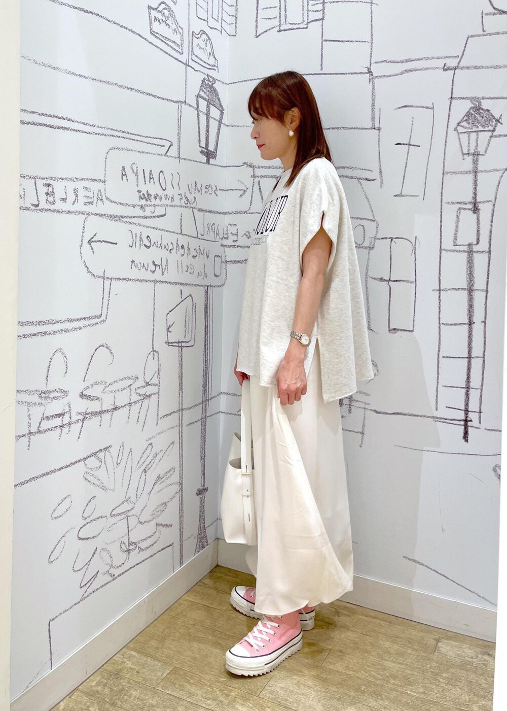 ホワイト系のショルダーバッグ、グレー系のTシャツ/カットソー、ホワイト系のスカートを着用したレディースの春コーディネートの3枚目の写真