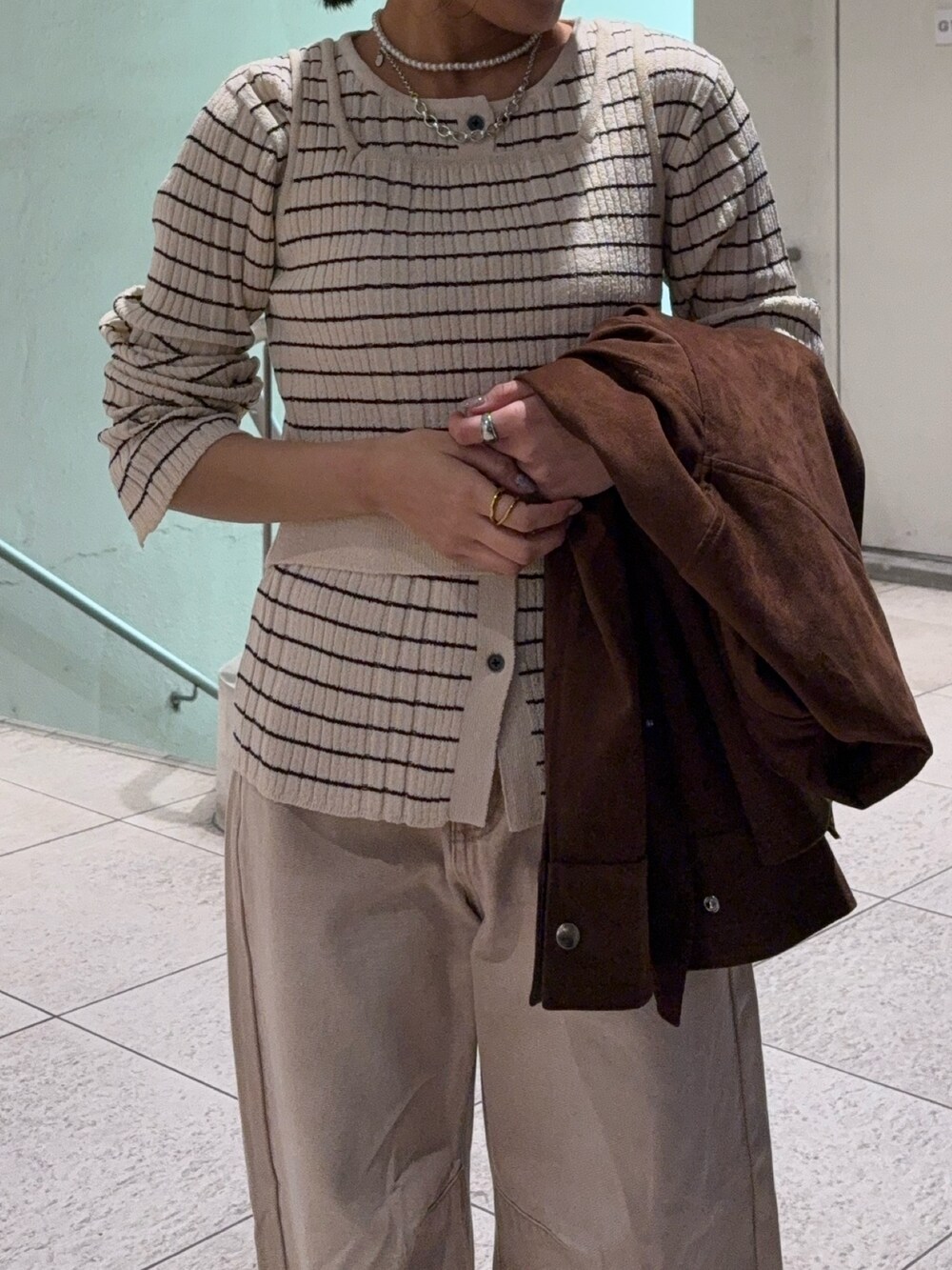 ブラウン系のその他アウター、ホワイト系のニット/セーター、ベージュ系のデニムパンツを着用したレディースの冬コーディネートの2枚目の写真