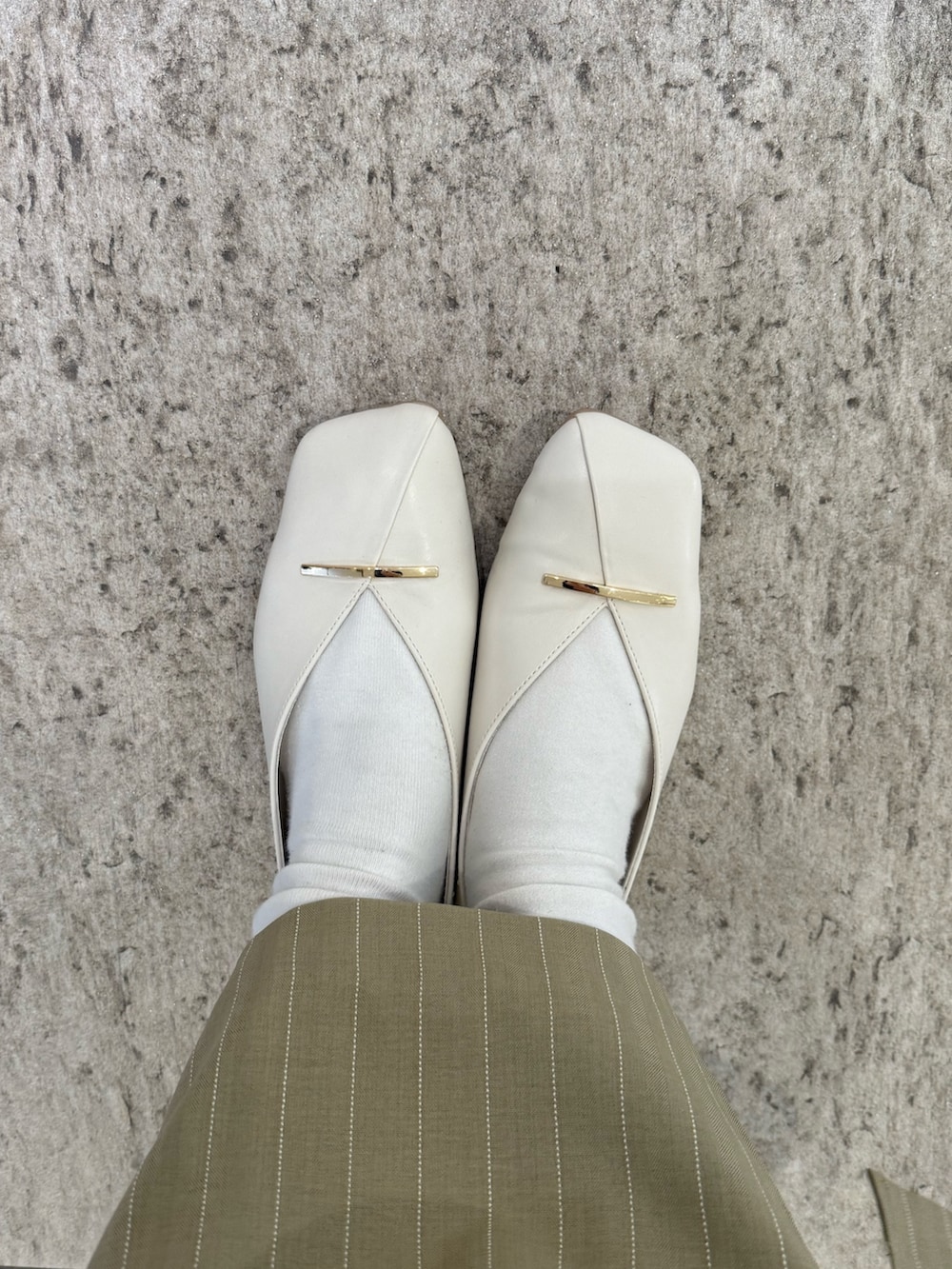 ブルー系のニット/セーター、ベージュ系のスカート、ホワイト系のTシャツ/カットソーを着用したレディースの春コーディネートの5枚目の写真