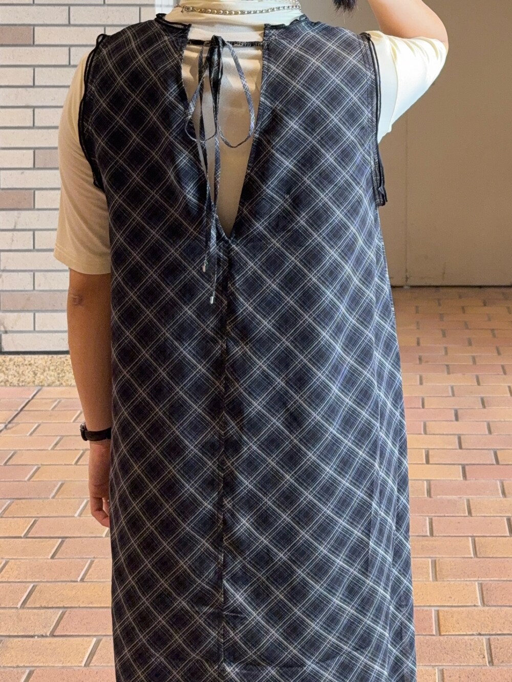 ブラック系のワンピース、ホワイト系のTシャツ/カットソー、ブラウン系のバレエシューズを着用したレディースの春コーディネートの3枚目の写真