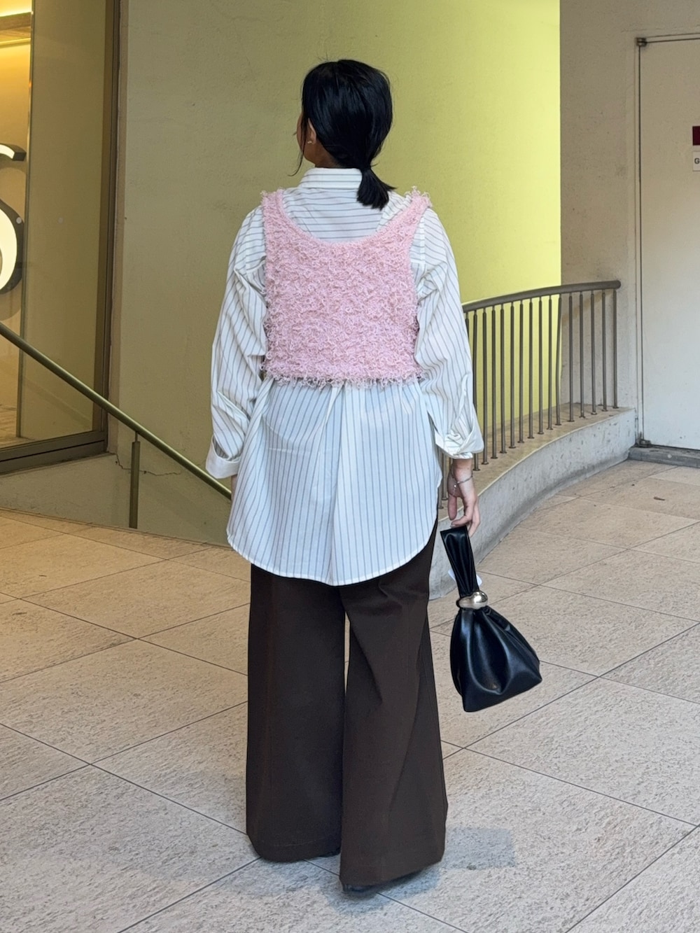 ホワイト系のシャツ/ブラウス、ピンク系のベスト、ブラウン系のハンドバッグを着用したレディースの冬コーディネートの2枚目の写真