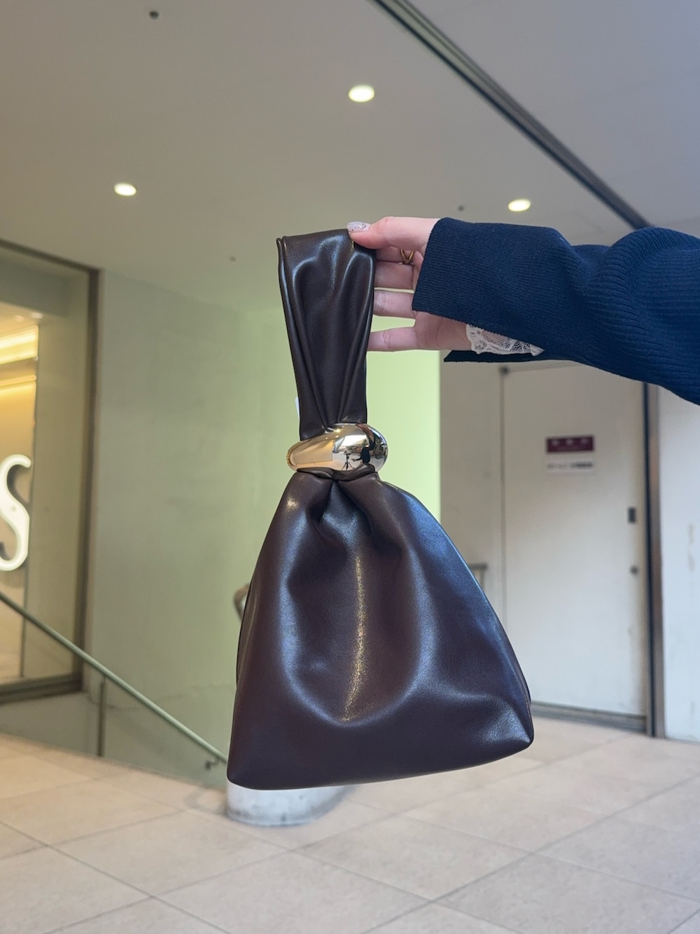 ブルー系のカーディガン/ボレロ、ホワイト系のその他トップス、ベージュ系のスラックスを着用したレディースの冬コーディネートの4枚目の写真