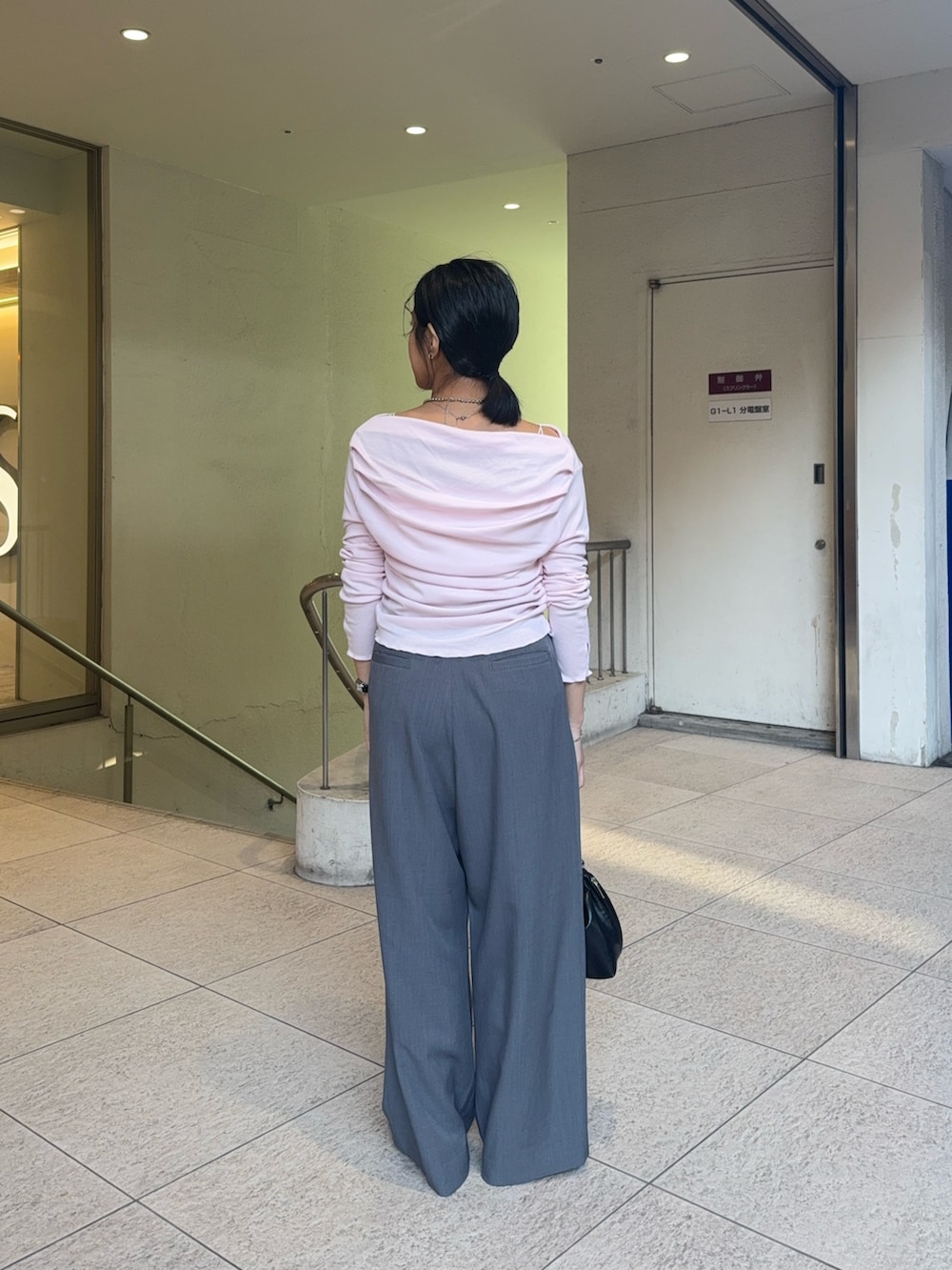 グレー系のスラックス、ブラウン系のハンドバッグ、ブラック系のローファーを着用したレディースの冬コーディネートの4枚目の写真