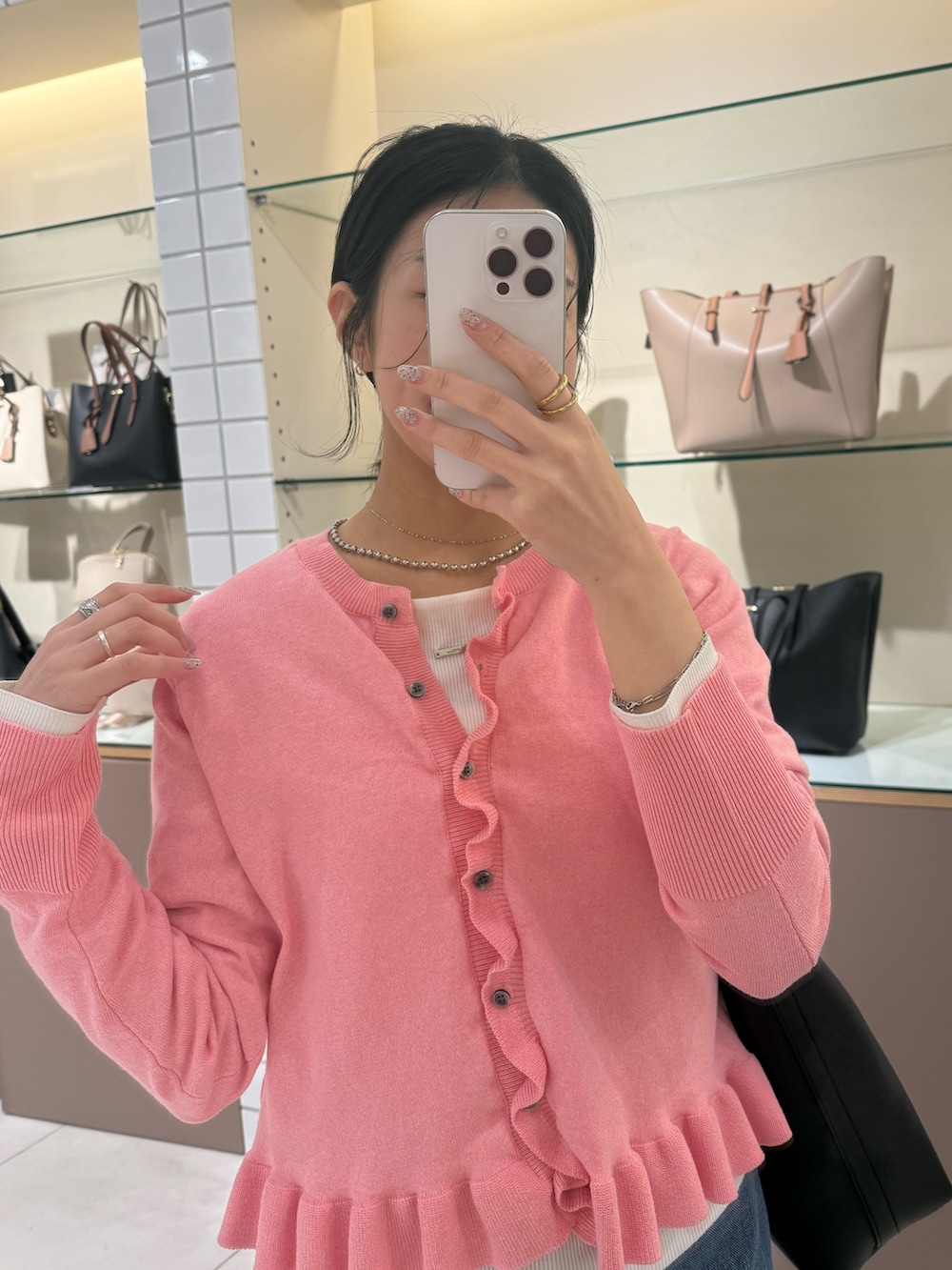 ピンク系のニット/セーター、ブルー系のデニムパンツ、ホワイト系のTシャツ/カットソーを着用したレディースの冬コーディネートの6枚目の写真