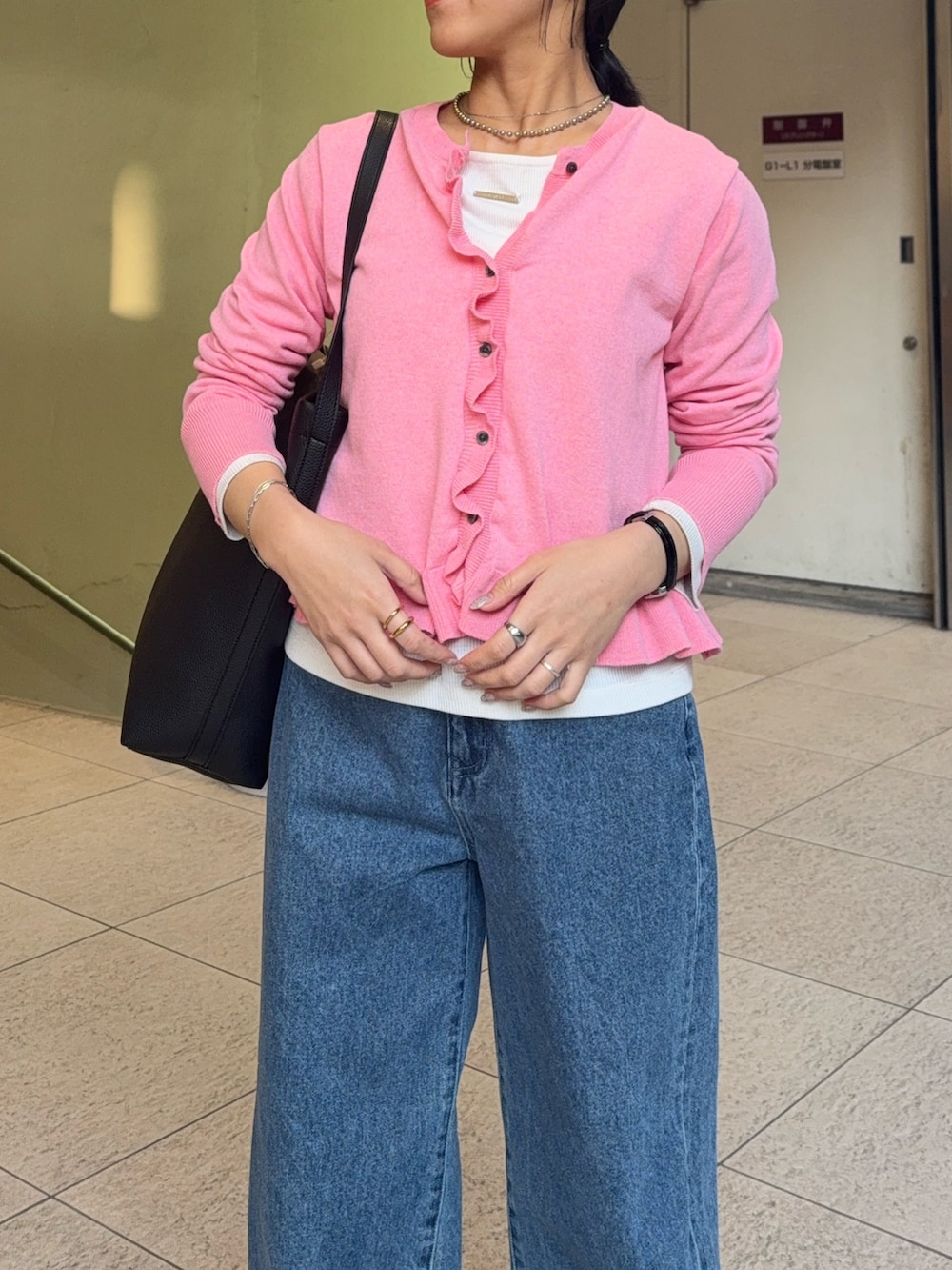 ピンク系のニット/セーター、ブルー系のデニムパンツ、ホワイト系のTシャツ/カットソーを着用したレディースの冬コーディネートの2枚目の写真