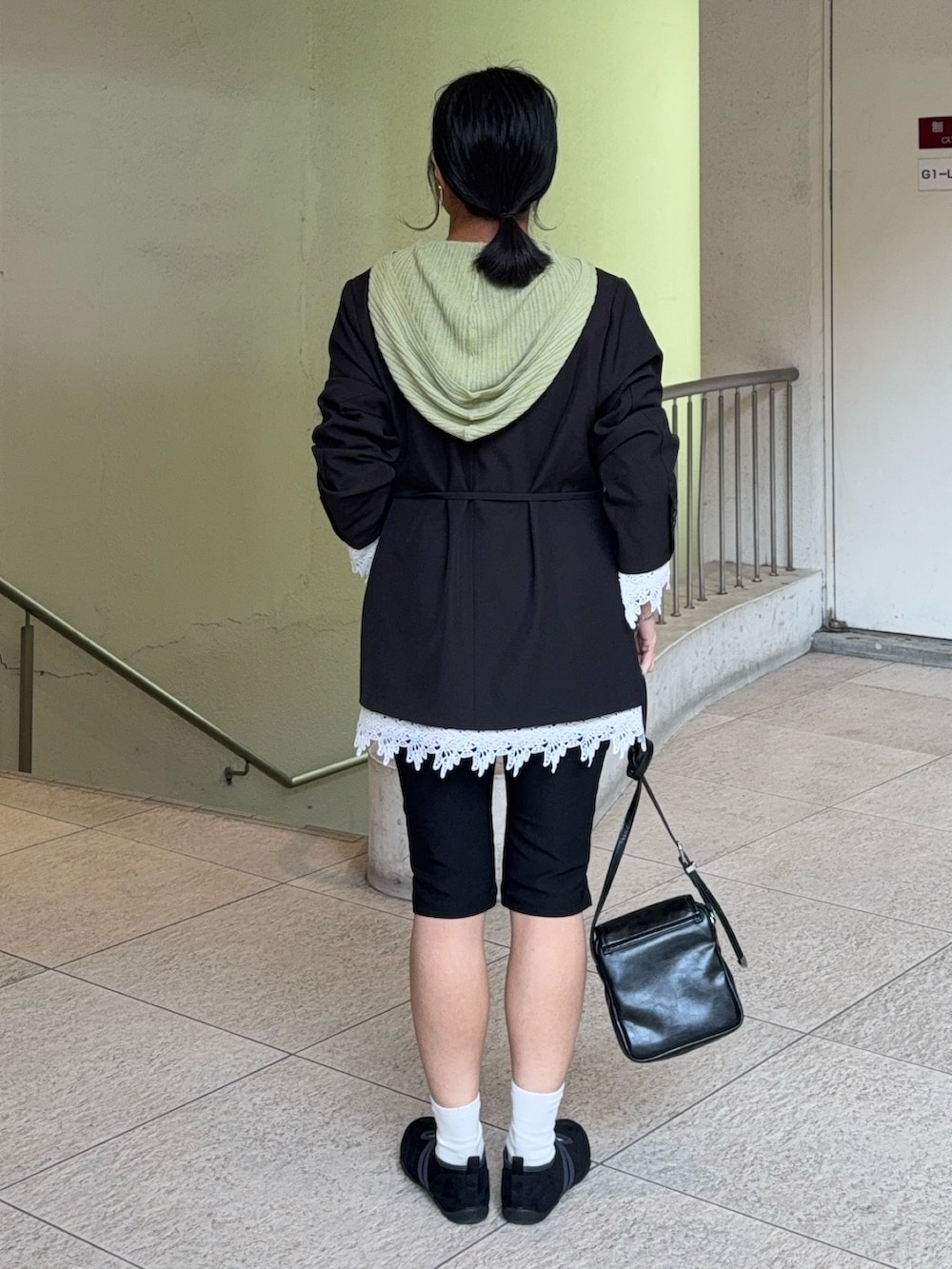 ブラック系のノーカラージャケット、ベージュ系のニット/セーター、ブラック系のその他パンツを着用したレディースの春コーディネートの3枚目の写真