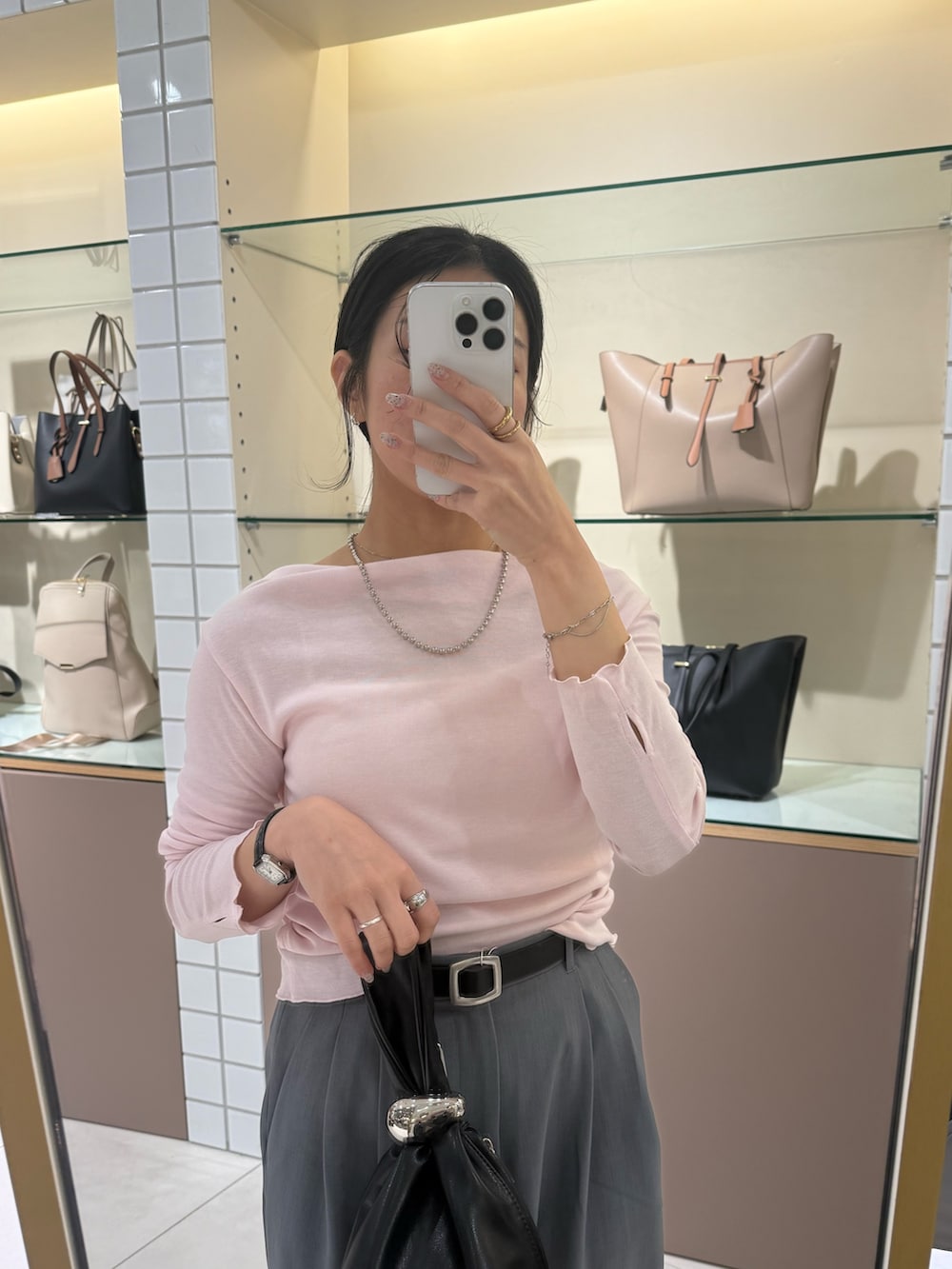 グレー系のスラックス、ブラウン系のハンドバッグ、ブラック系のローファーを着用したレディースの冬コーディネートの6枚目の写真