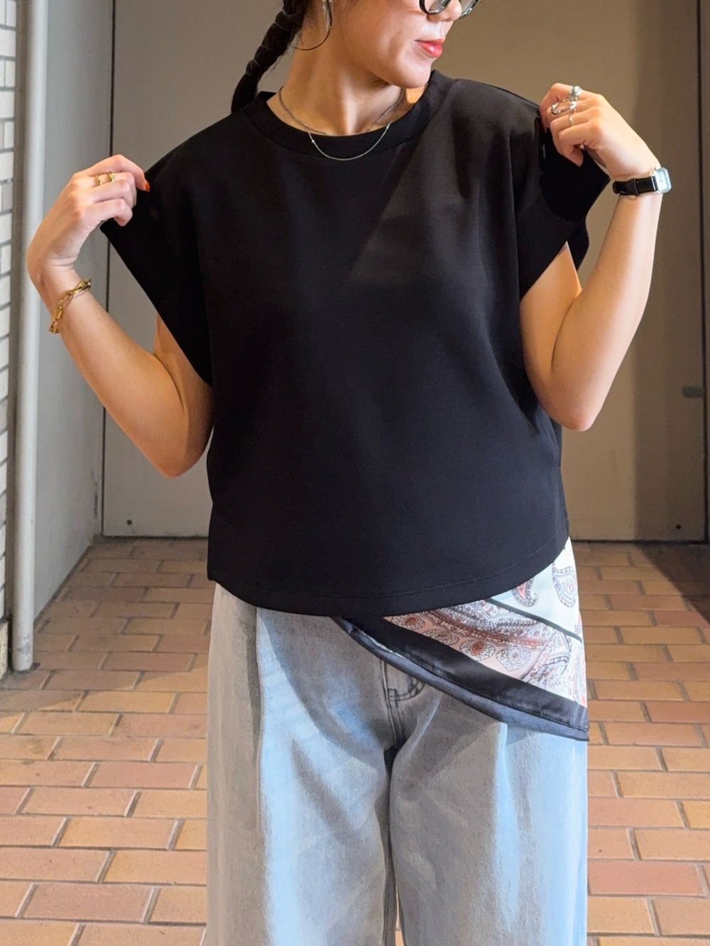 ブラック系のTシャツ/カットソー、ブルー系のデニムパンツ、ブラック系のパンプスを着用したレディースの夏コーディネートの4枚目の写真