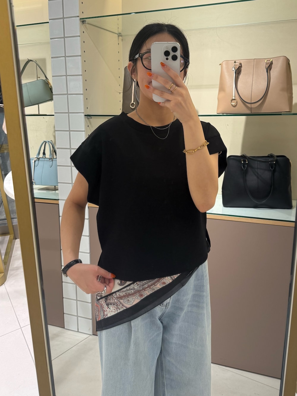 ブラック系のTシャツ/カットソー、ブルー系のデニムパンツ、ブラック系のパンプスを着用したレディースの夏コーディネートの5枚目の写真