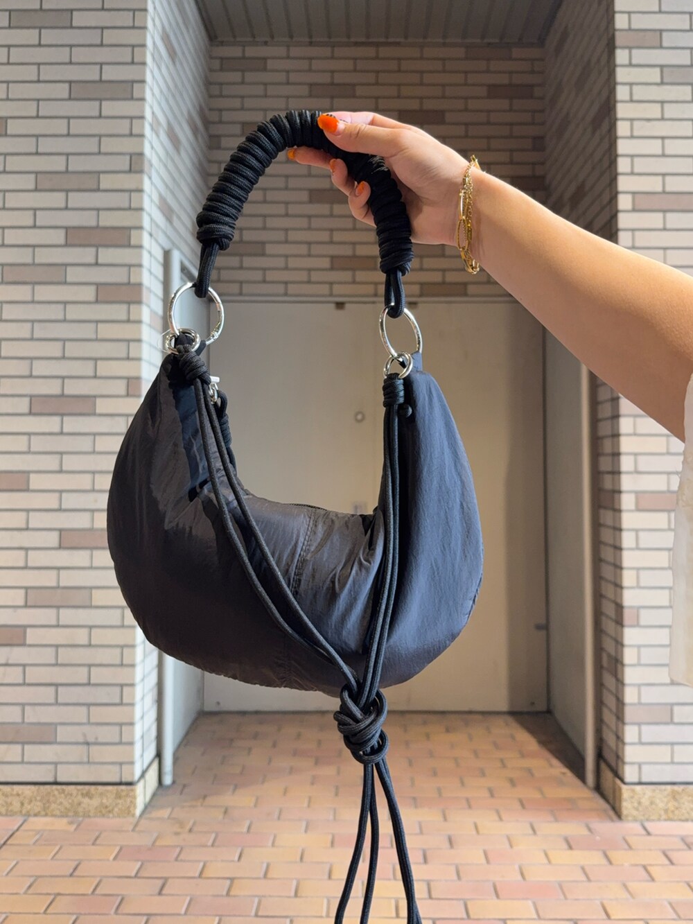 ホワイト系のシャツ/ブラウス、ブラック系のハンドバッグ、グレー系のスカートを着用したレディースの夏コーディネートの5枚目の写真