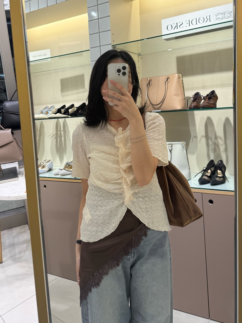 ホワイト系のカーディガン/ボレロ、ブルー系のデニムパンツ、ブラック系のローファーを着用したレディースの夏コーディネートの5枚目の写真