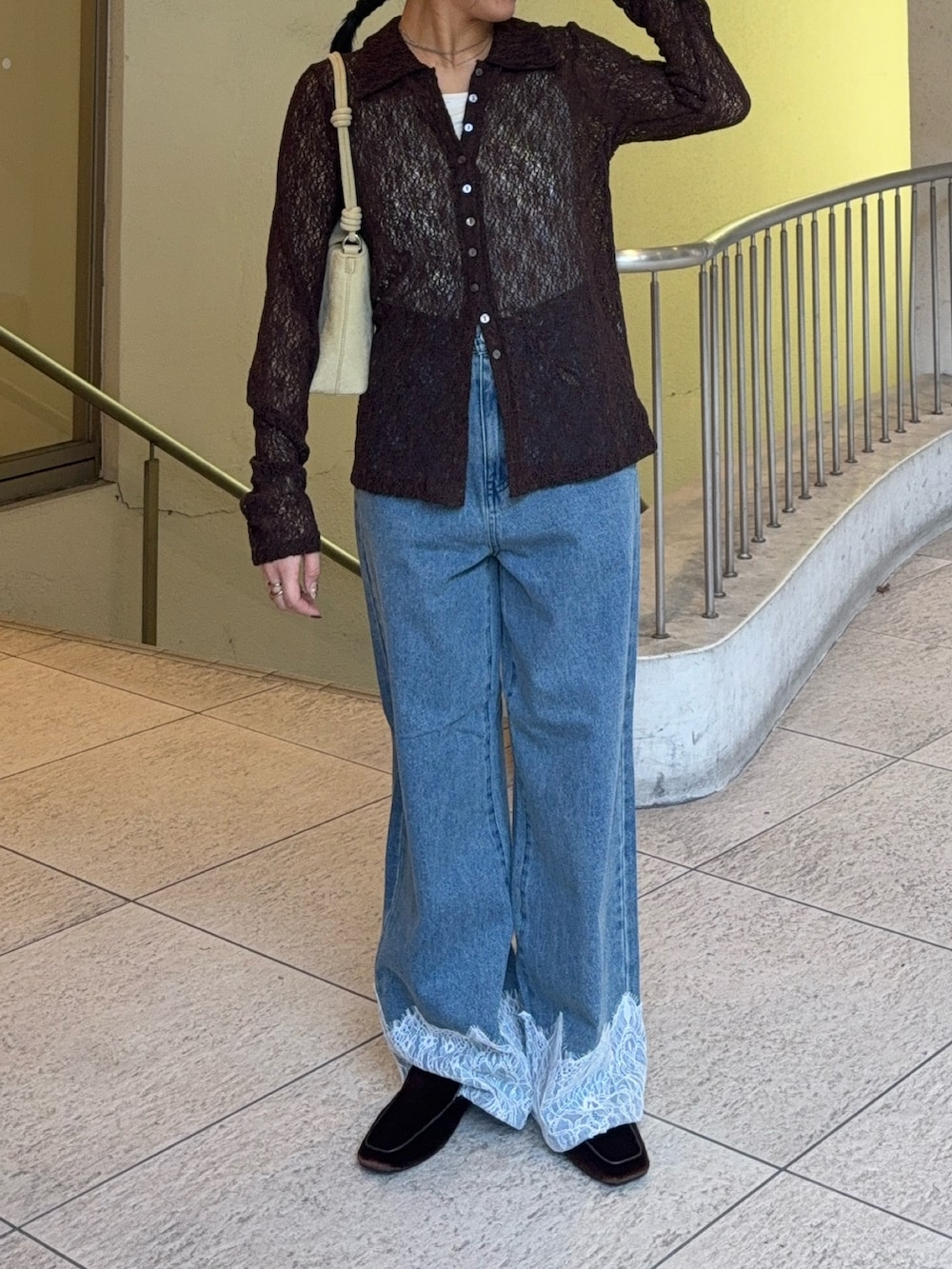 ベージュ系のハンドバッグ、ブルー系のデニムパンツ、ブラック系のその他シューズを着用したレディースの秋コーディネートの2枚目の写真