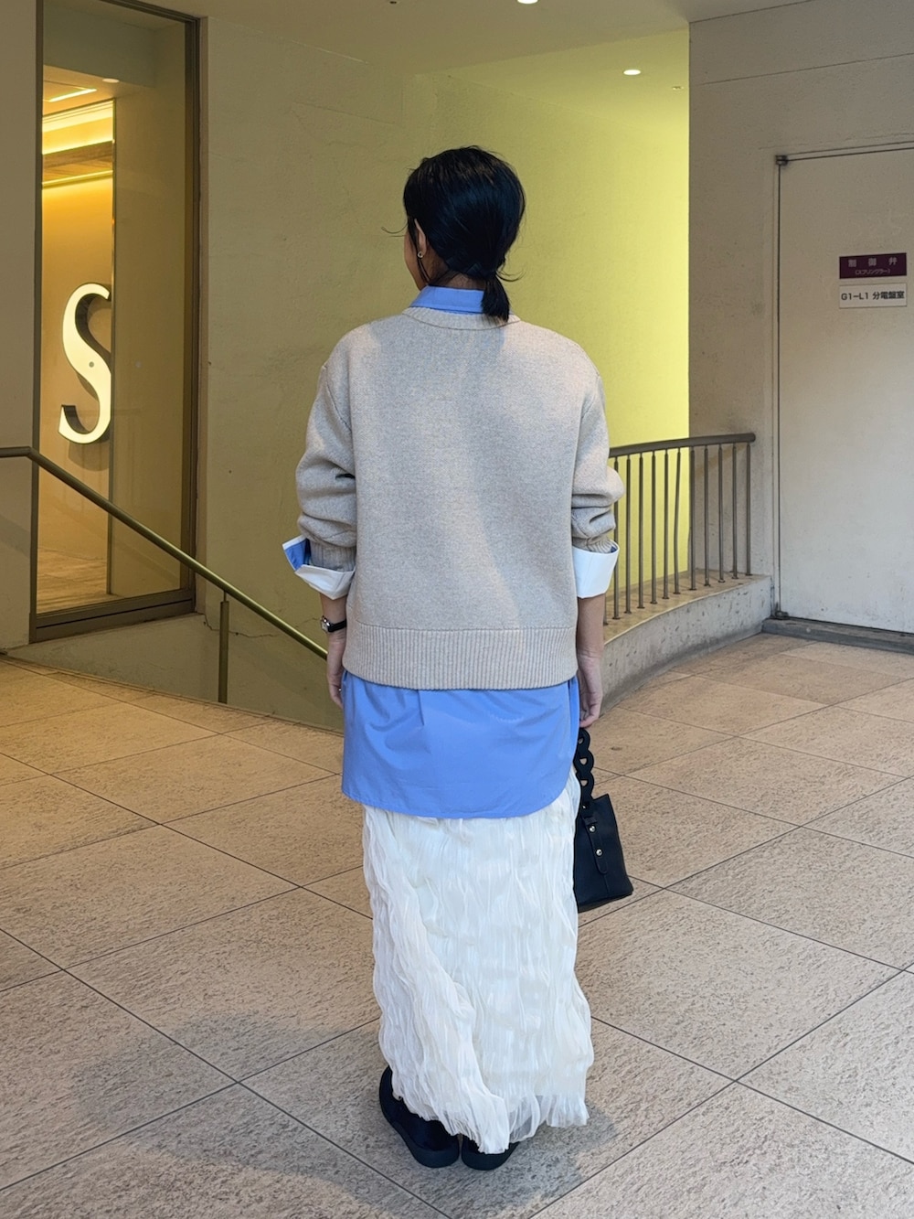 ブルー系のシャツ/ブラウス、ベージュ系のニット/セーター、ホワイト系のスカートを着用したレディースの冬コーディネートの3枚目の写真