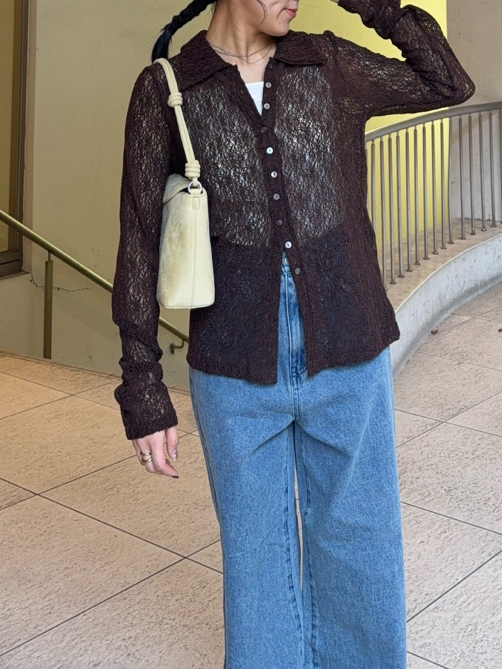 ベージュ系のハンドバッグ、ブルー系のデニムパンツ、ブラック系のその他シューズを着用したレディースの秋コーディネートの3枚目の写真