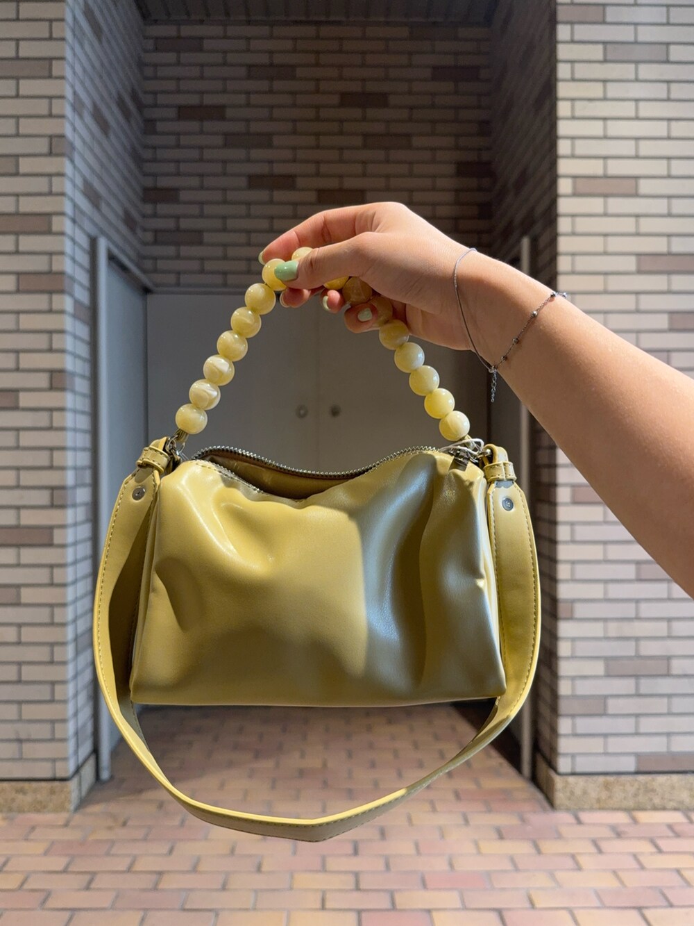 ブラック系のシャツ/ブラウス、ブルー系のその他パンツ、ベージュ系のショルダーバッグを着用したレディースの夏コーディネートの4枚目の写真