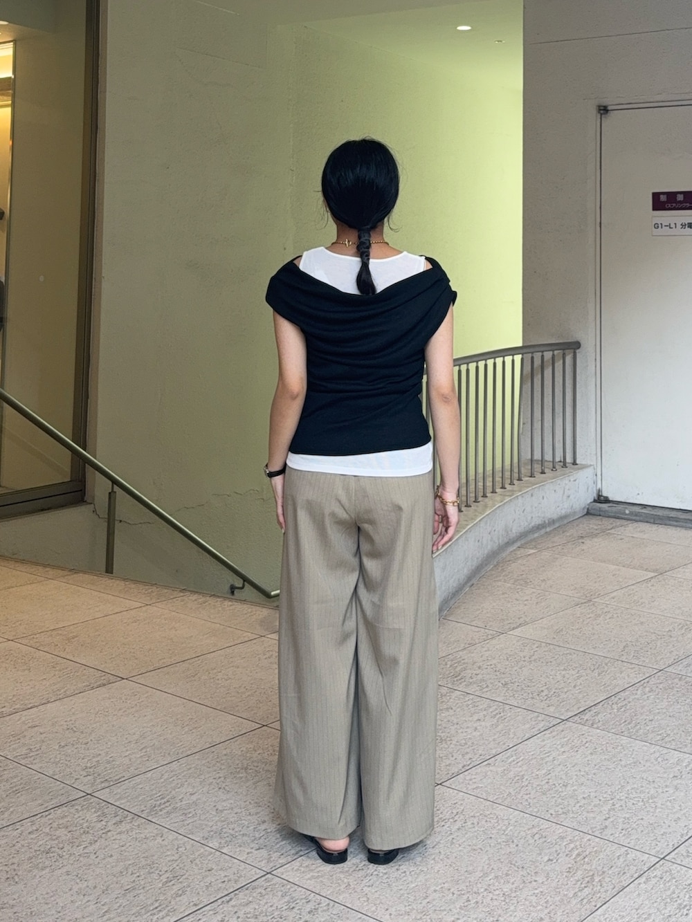 ブラック系のタンクトップ、ベージュ系のスラックス、ブラック系のパンプスを着用したレディースの夏コーディネートの4枚目の写真