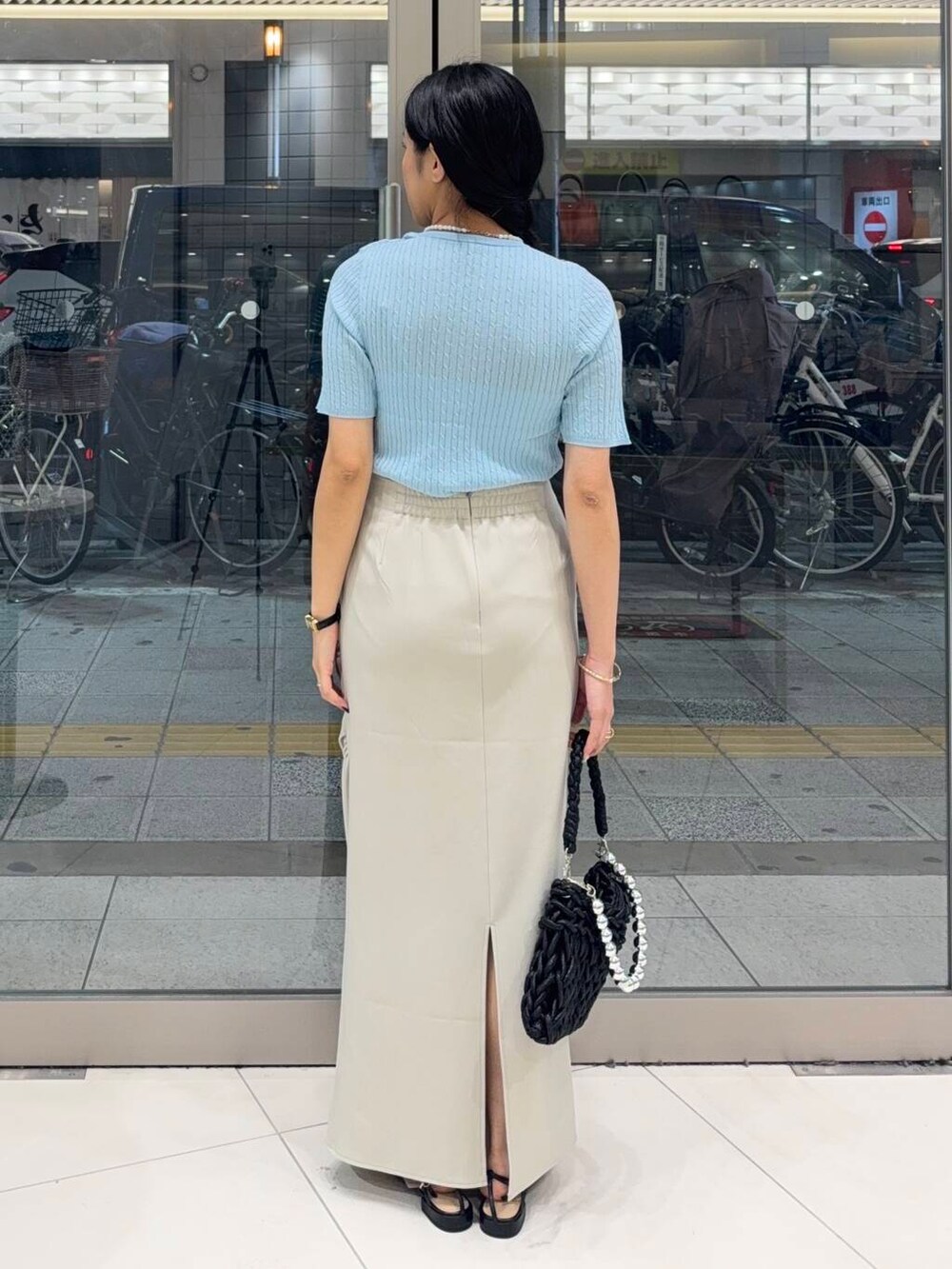 ブラック系のハンドバッグ、ホワイト系のキャミソール、ブラック系のサンダルを着用したレディースの夏コーディネートの3枚目の写真