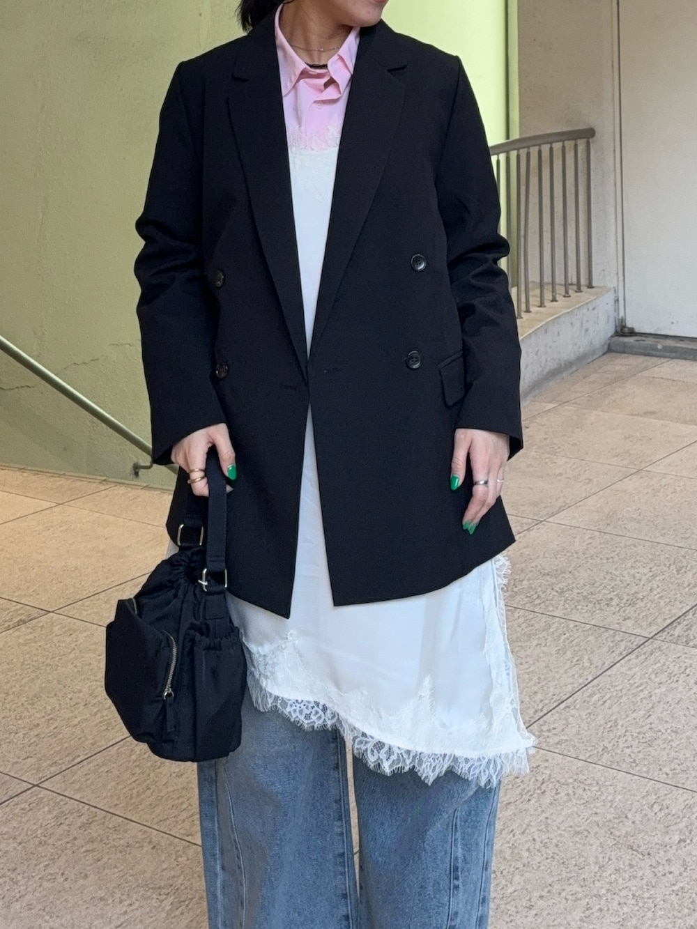 ホワイト系のキャミソール、ブルー系のデニムパンツ、ブラック系のテーラードジャケットを着用したレディースの春コーディネートの4枚目の写真