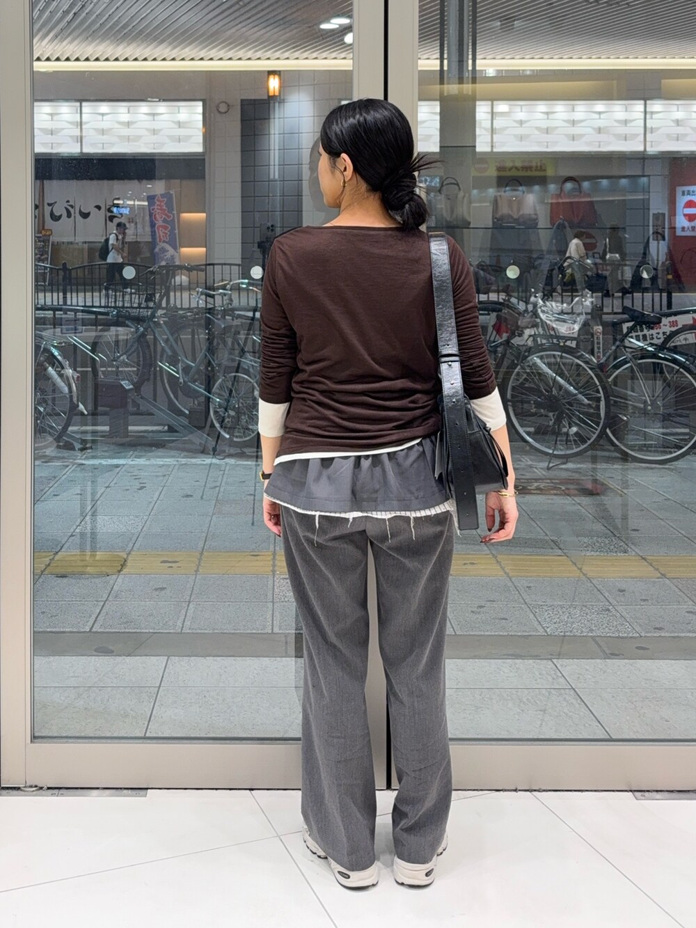 グレー系のスカート、グレー系のその他パンツ、ブラウン系のTシャツ/カットソーを着用したレディースの秋コーディネートの2枚目の写真