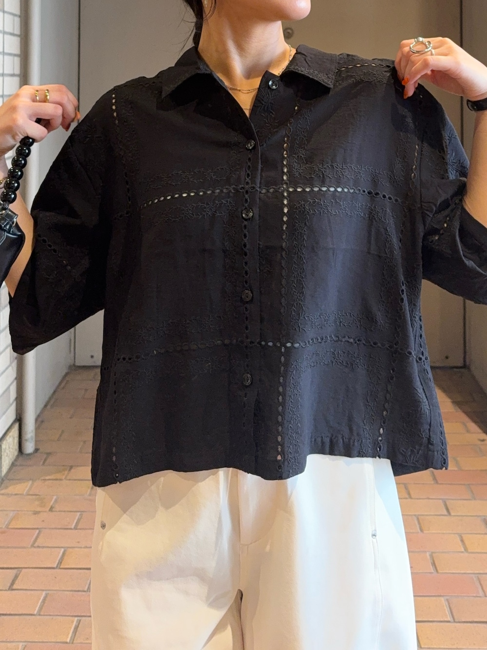 ブラック系のシャツ/ブラウス、ブラック系のショルダーバッグ、ホワイト系のその他パンツを着用したレディースの夏コーディネートの3枚目の写真