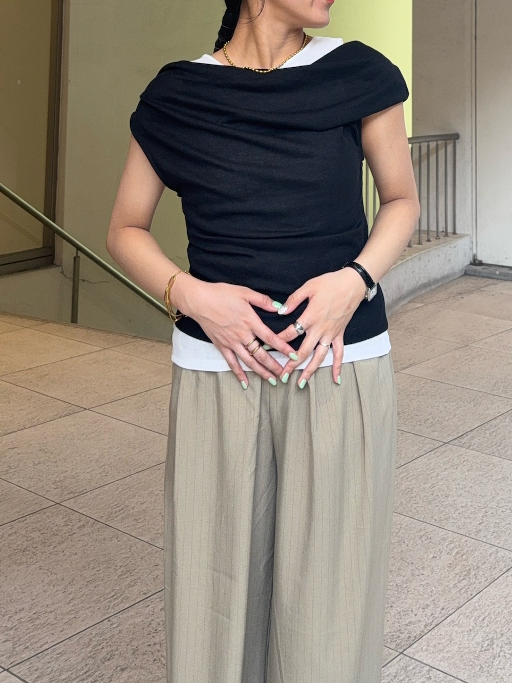 ブラック系のタンクトップ、ベージュ系のスラックス、ブラック系のパンプスを着用したレディースの夏コーディネートの3枚目の写真