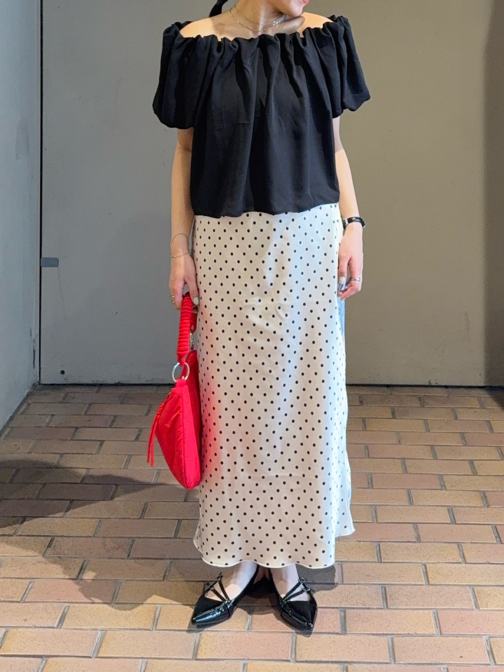 ブラック系のシャツ/ブラウス、ホワイト系のスカート、ブラック系のパンプスを着用したレディースの夏コーディネートの2枚目の写真