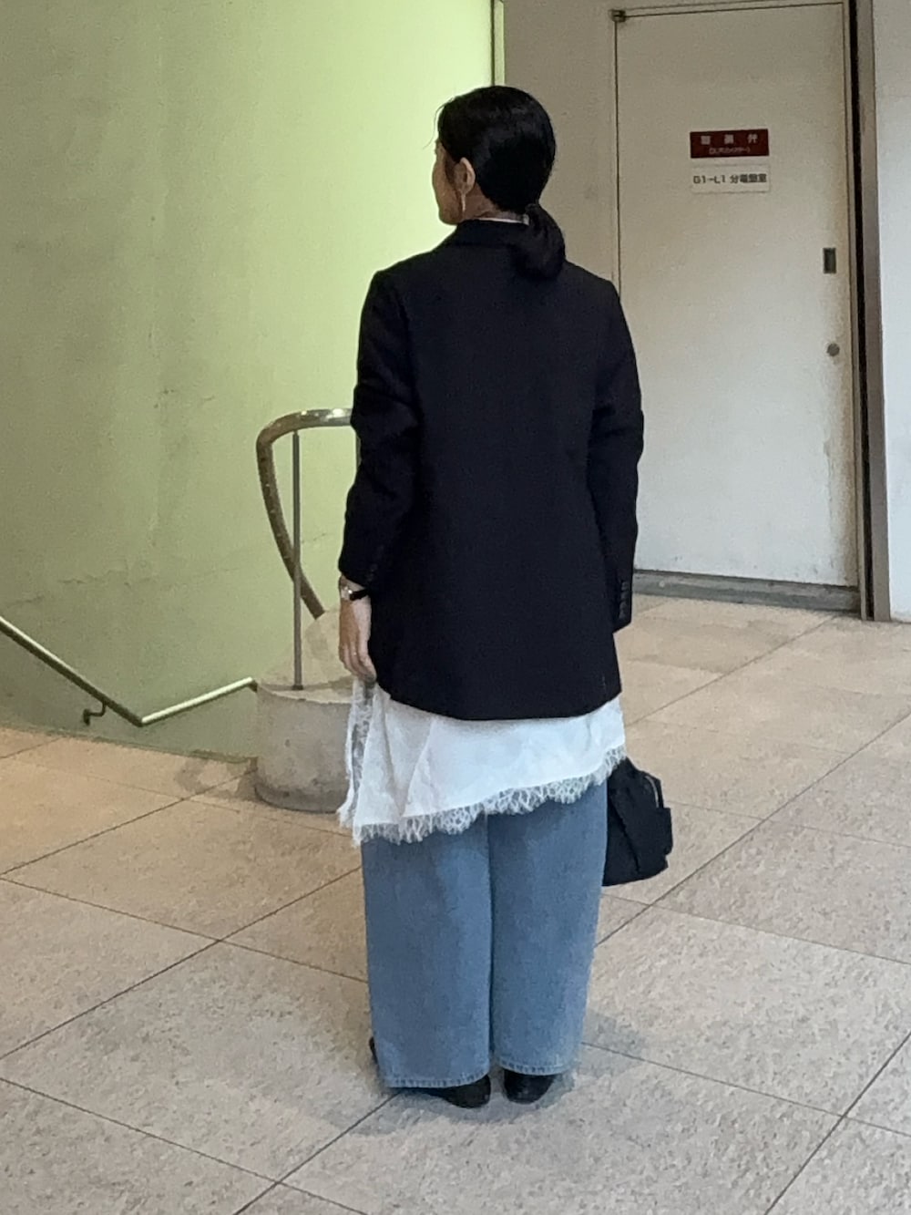 ホワイト系のキャミソール、ブルー系のデニムパンツ、ブラック系のテーラードジャケットを着用したレディースの春コーディネートの3枚目の写真