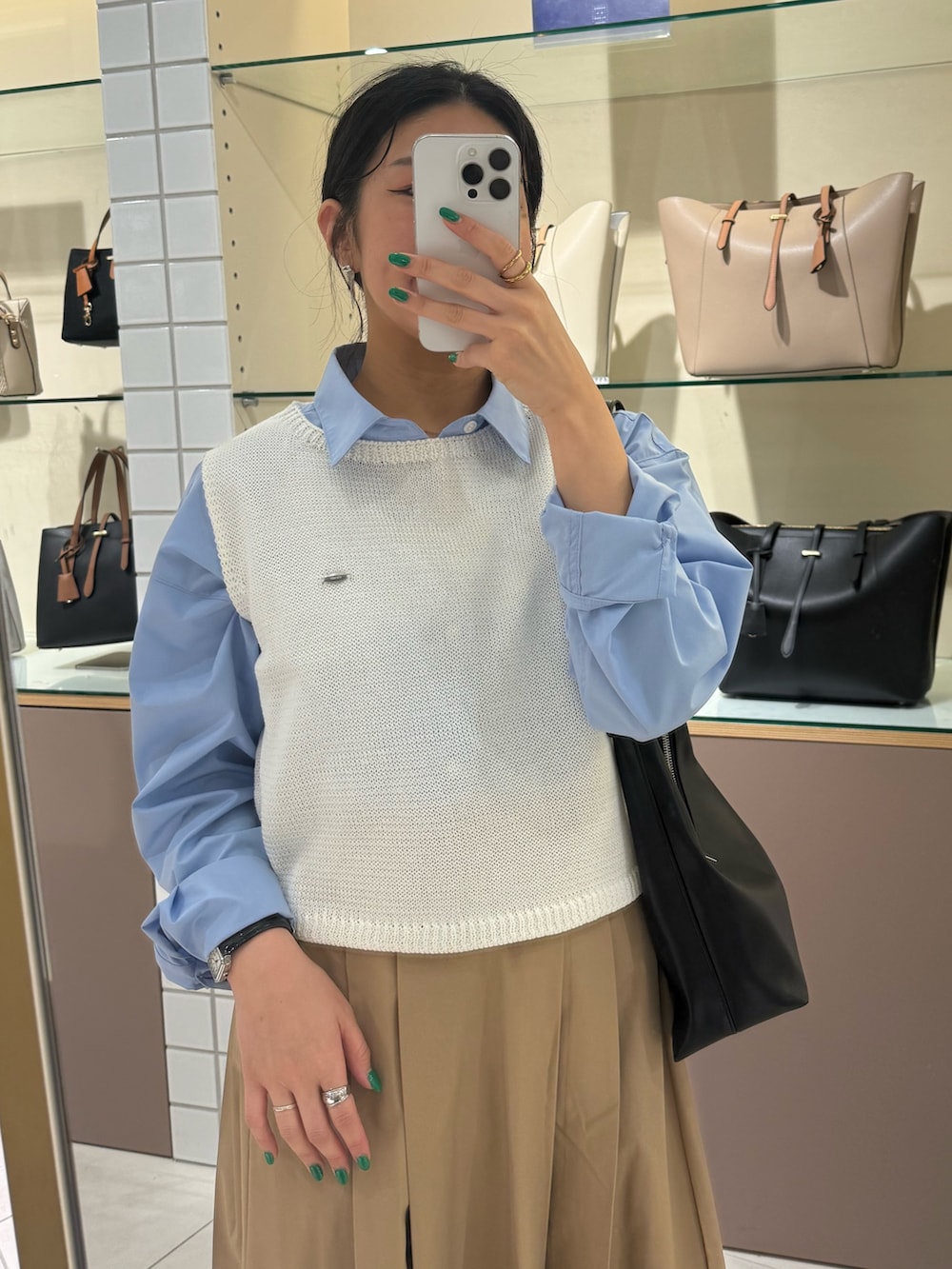 ベージュ系のスカート、ホワイト系のニット/セーター、ブルー系のシャツ/ブラウスを着用したレディースの春コーディネートの6枚目の写真