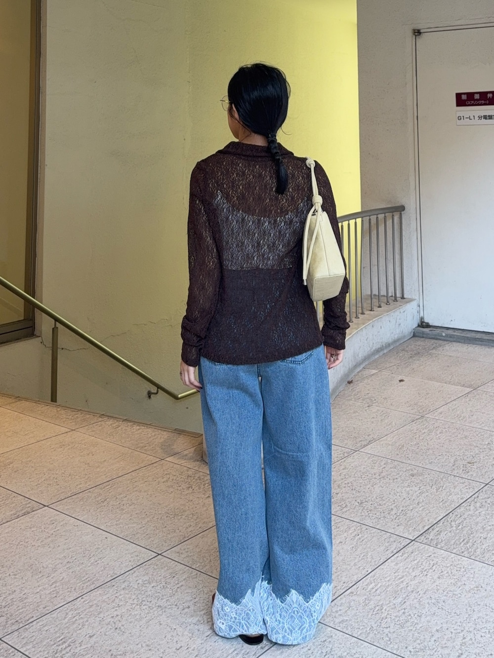 ベージュ系のハンドバッグ、ブルー系のデニムパンツ、ブラック系のその他シューズを着用したレディースの秋コーディネートの4枚目の写真
