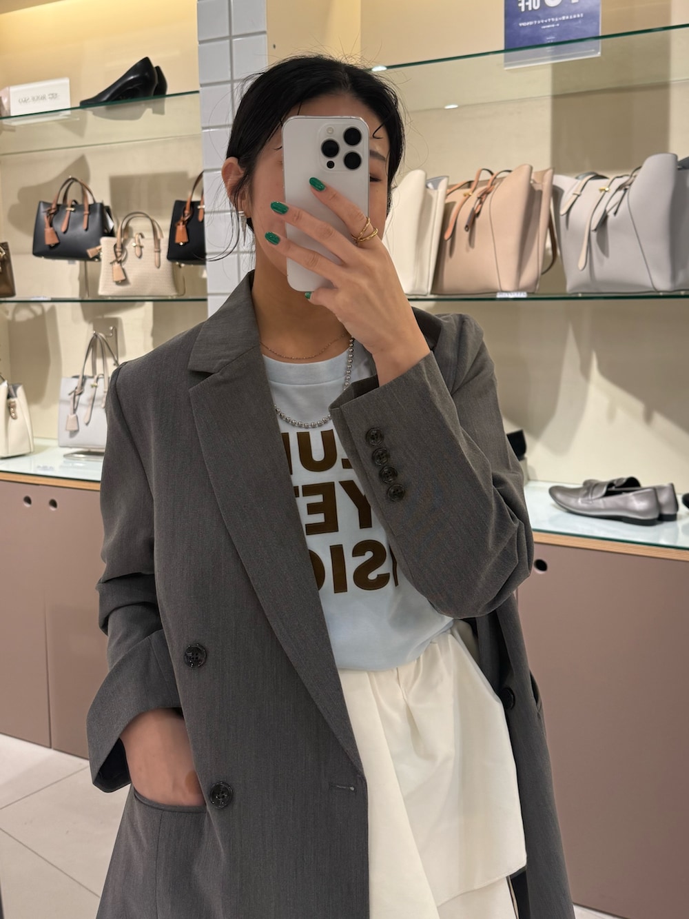 グレー系のテーラードジャケット、その他のTシャツ/カットソー、ホワイト系のスカートを着用したレディースの春コーディネートの6枚目の写真