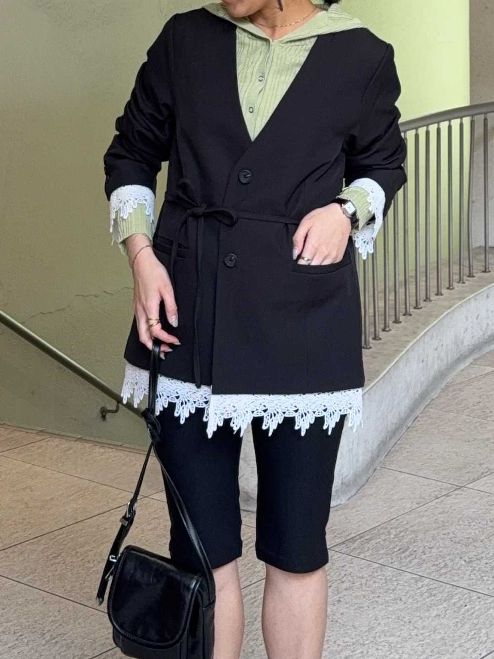 ブラック系のノーカラージャケット、ベージュ系のニット/セーター、ブラック系のその他パンツを着用したレディースの春コーディネートの2枚目の写真