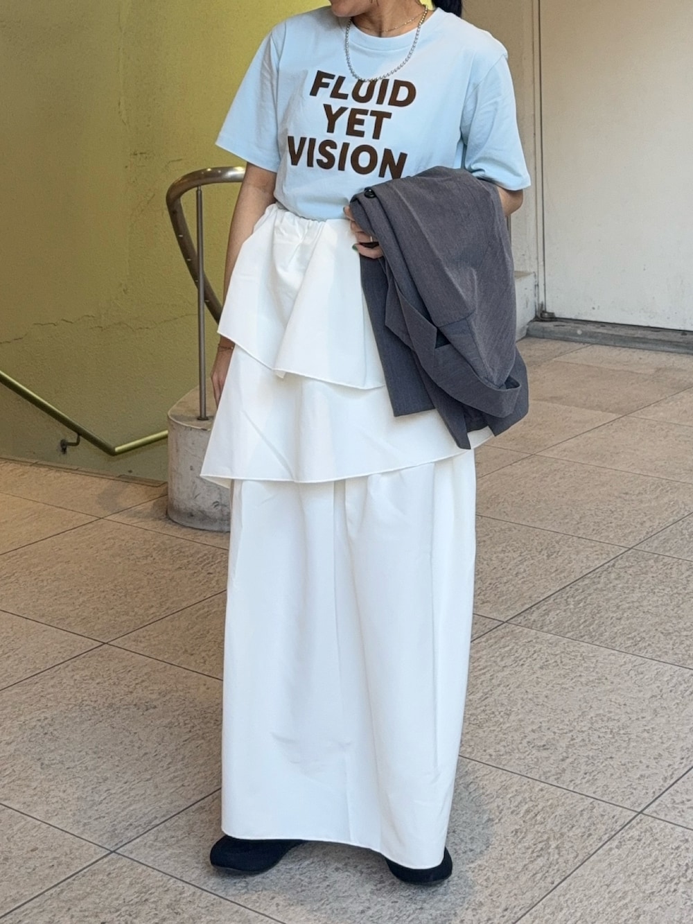 グレー系のテーラードジャケット、その他のTシャツ/カットソー、ホワイト系のスカートを着用したレディースの春コーディネートの3枚目の写真