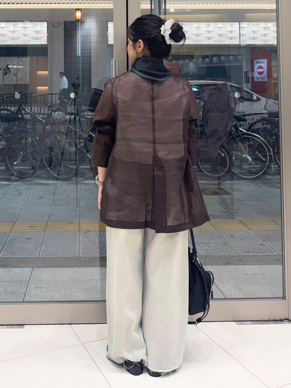 ブラック系のショルダーバッグ、ホワイト系のシャツ/ブラウス、ブルー系のデニムパンツを着用したレディースの夏コーディネートの2枚目の写真