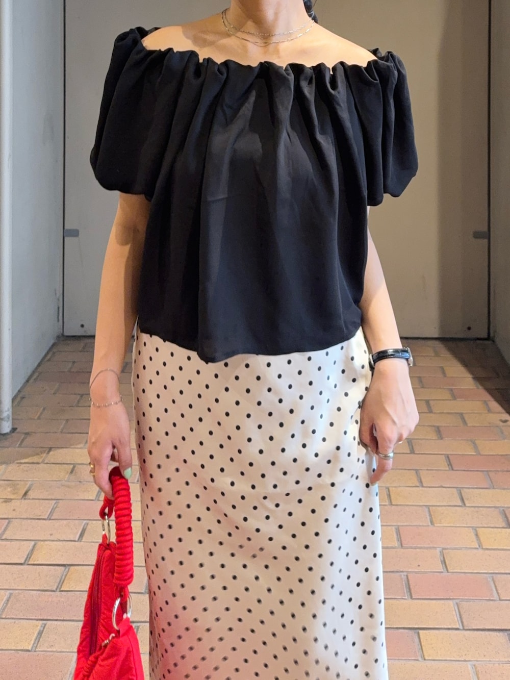 ブラック系のシャツ/ブラウス、ホワイト系のスカート、ブラック系のパンプスを着用したレディースの夏コーディネートの4枚目の写真