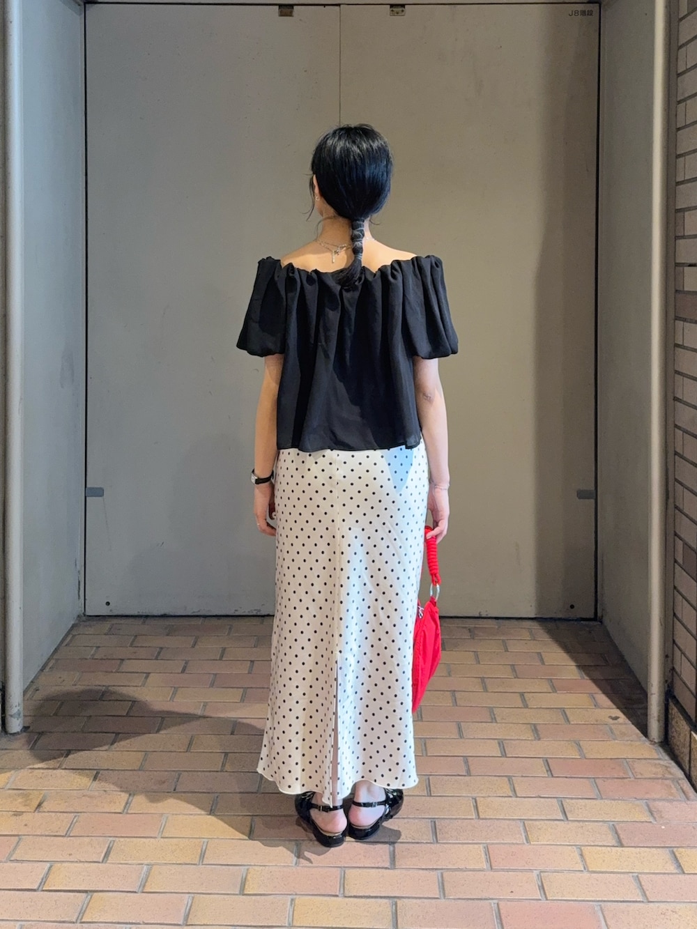 ブラック系のシャツ/ブラウス、ホワイト系のスカート、ブラック系のパンプスを着用したレディースの夏コーディネートの3枚目の写真