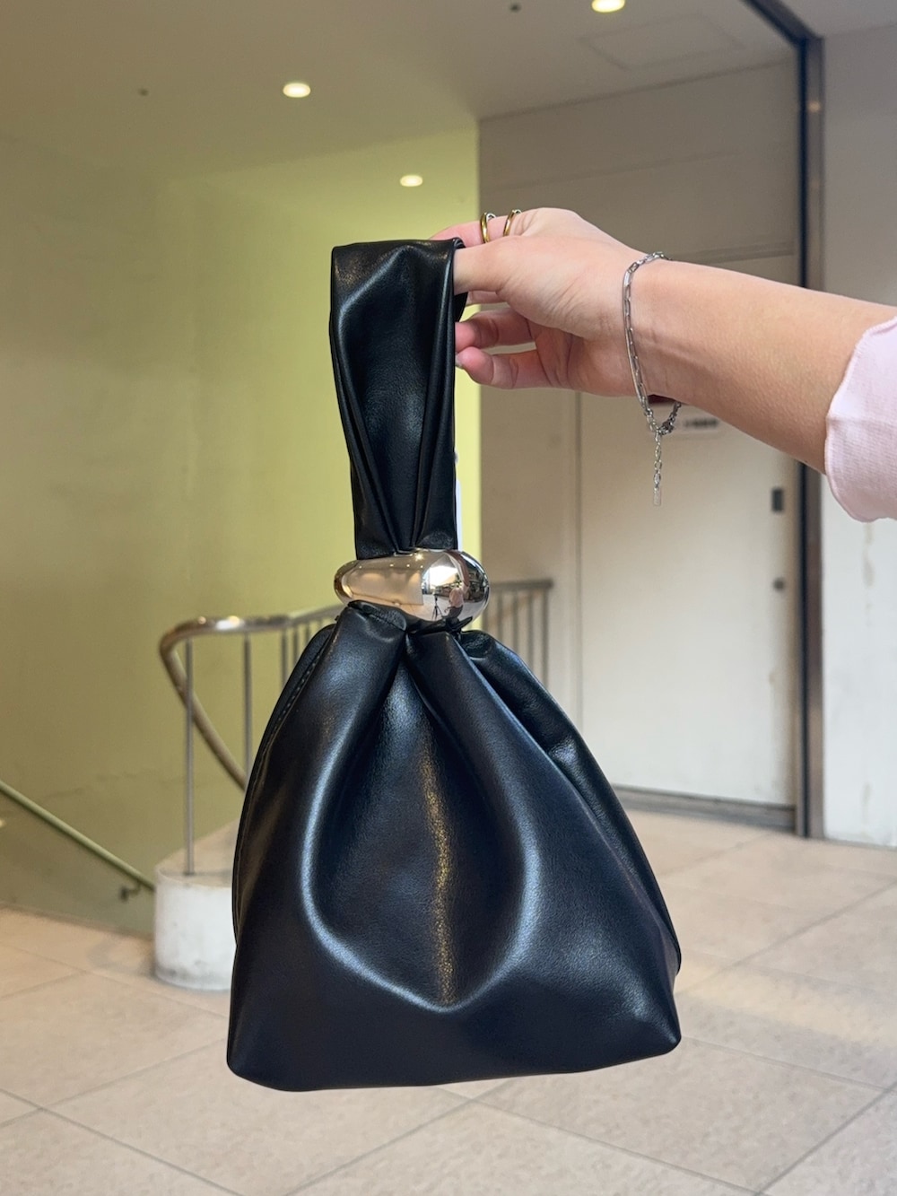 グレー系のスラックス、ブラウン系のハンドバッグ、ブラック系のローファーを着用したレディースの冬コーディネートの5枚目の写真