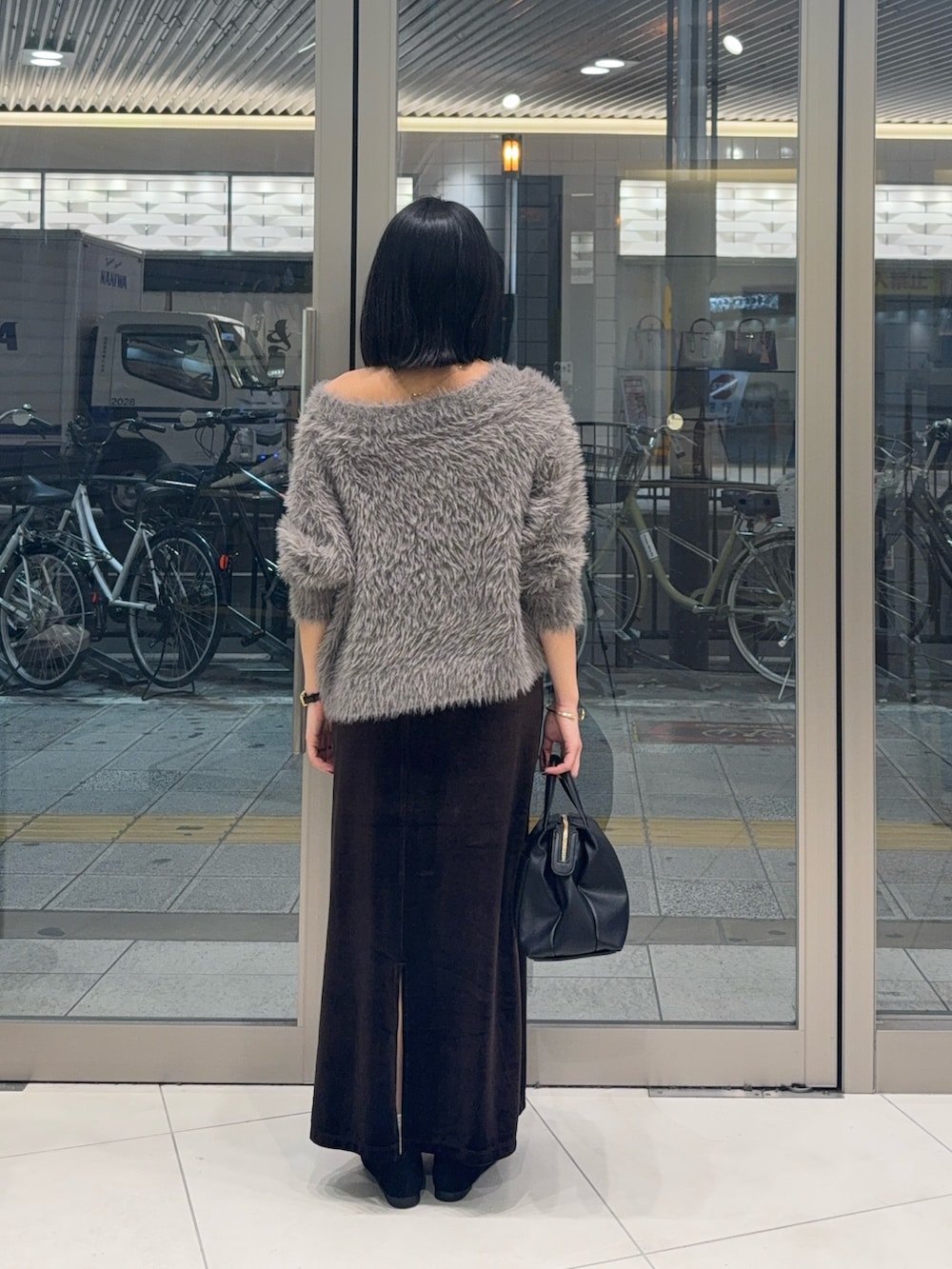 ブラウン系のニット/セーター、ブラウン系のスカート、ブラック系のローファーを着用したレディースの秋コーディネートの2枚目の写真