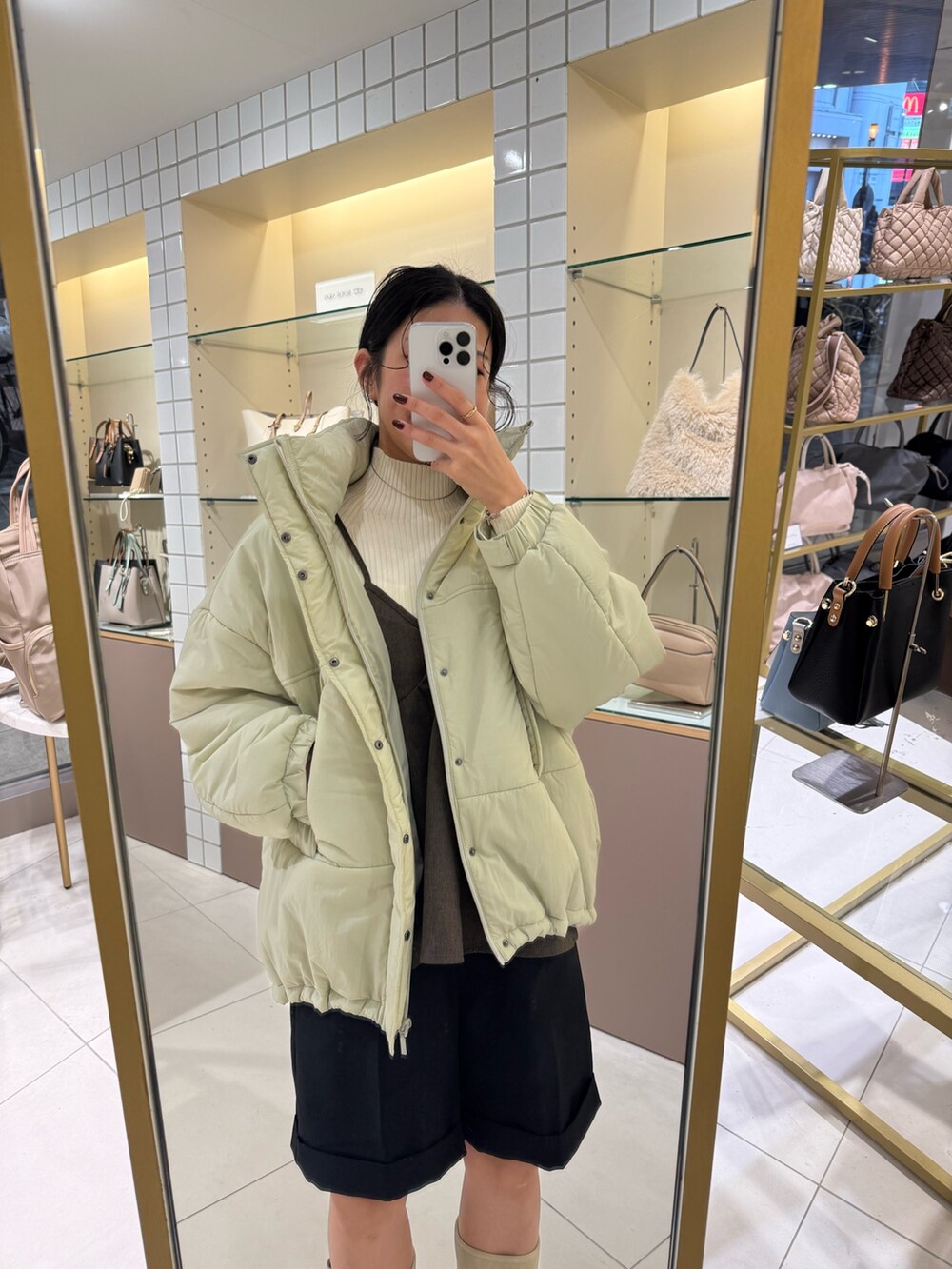 ベージュ系のブーツ、ブラック系のその他パンツ、ホワイト系のニット/セーターを着用したレディースの秋コーディネートの6枚目の写真
