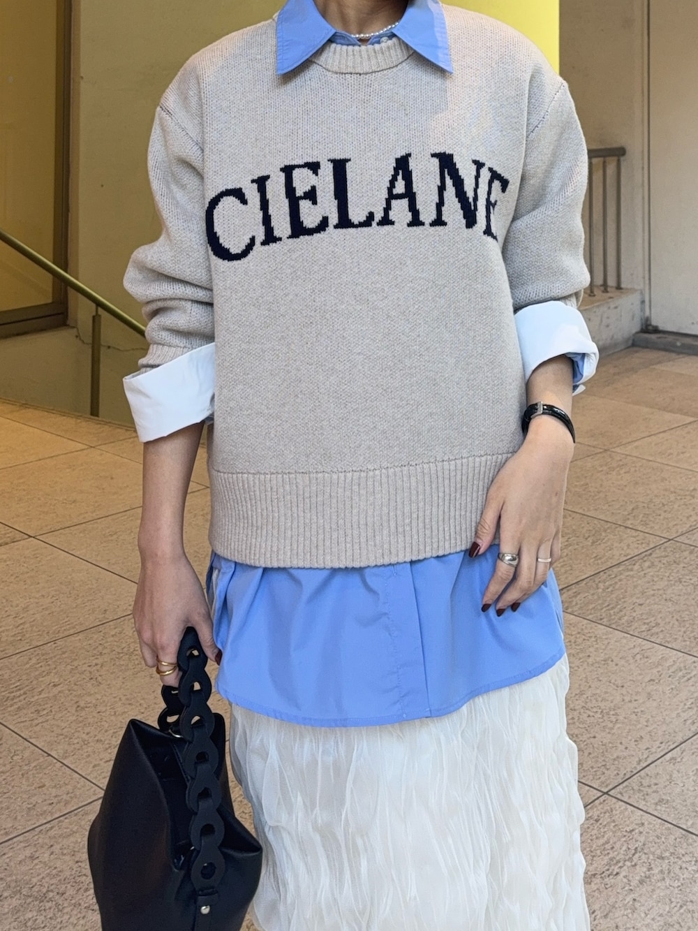 ブルー系のシャツ/ブラウス、ベージュ系のニット/セーター、ホワイト系のスカートを着用したレディースの冬コーディネートの4枚目の写真