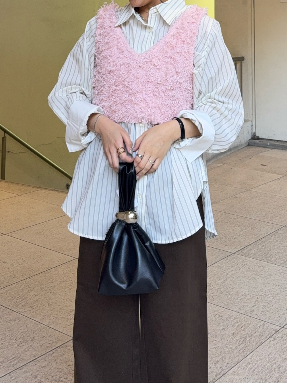 ホワイト系のシャツ/ブラウス、ピンク系のベスト、ブラウン系のハンドバッグを着用したレディースの冬コーディネートの3枚目の写真