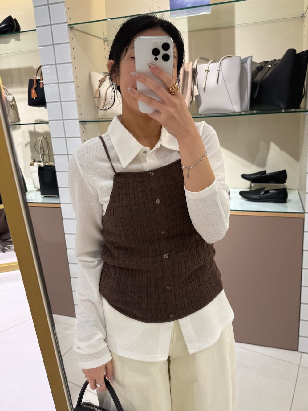 ブラウン系のキャミソール、ホワイト系のシャツ/ブラウス、ブラック系のローファーを着用したレディースの春コーディネートの4枚目の写真