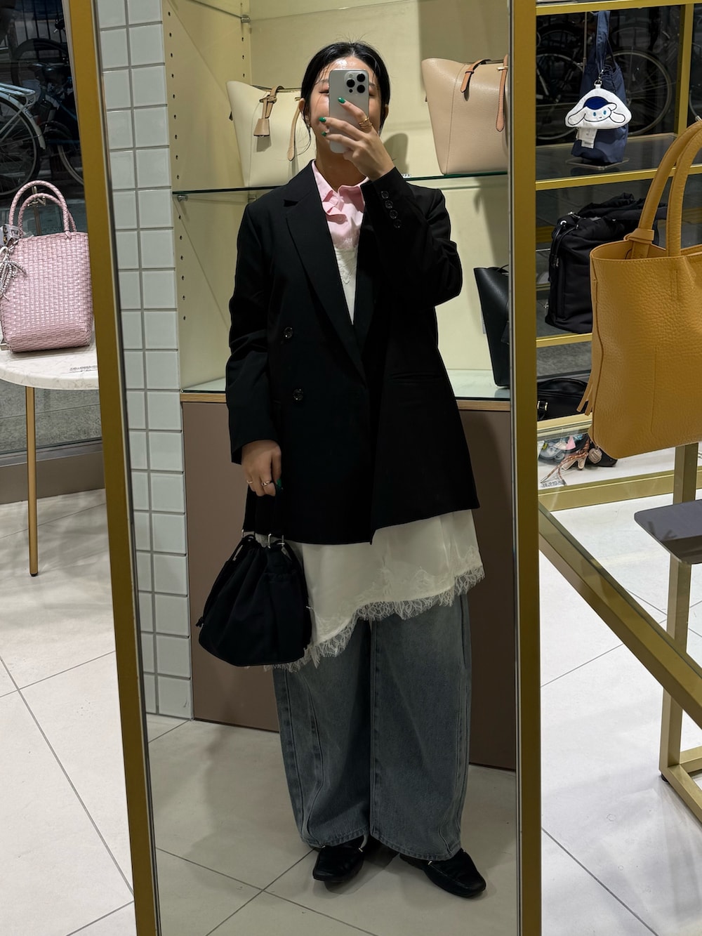 ホワイト系のキャミソール、ブルー系のデニムパンツ、ブラック系のテーラードジャケットを着用したレディースの春コーディネートの6枚目の写真