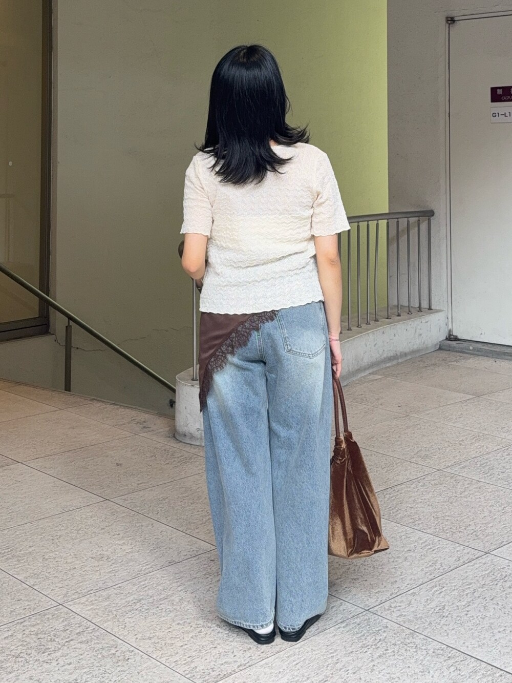 ホワイト系のカーディガン/ボレロ、ブルー系のデニムパンツ、ブラック系のローファーを着用したレディースの夏コーディネートの3枚目の写真