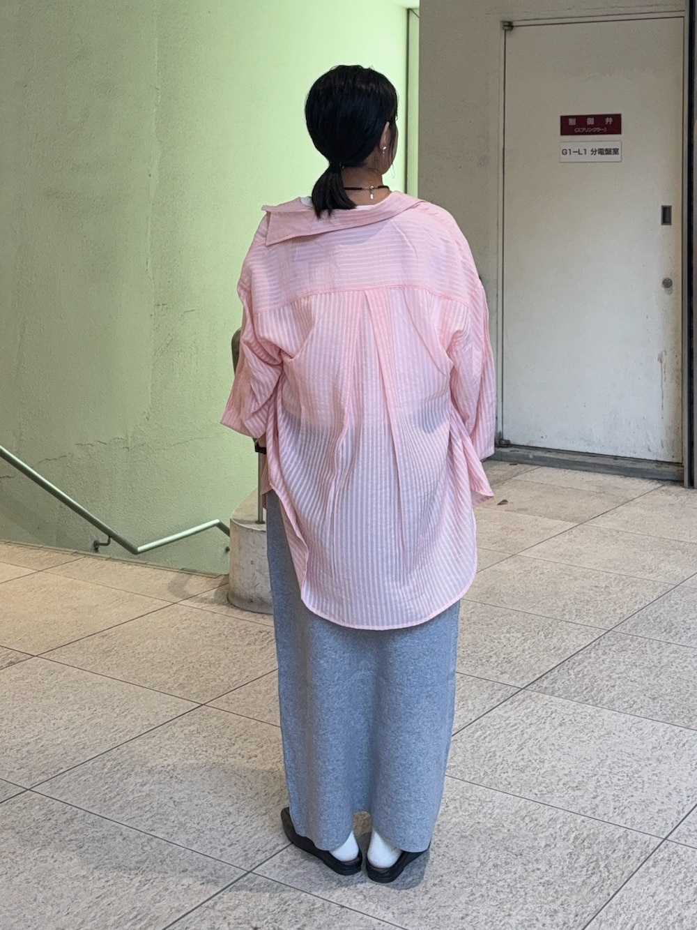 グレー系のスカート、ブラック系のローファー、ピンク系のシャツ/ブラウスを着用したレディースの春コーディネートの2枚目の写真