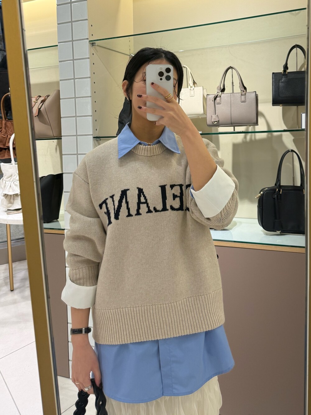 ブルー系のシャツ/ブラウス、ベージュ系のニット/セーター、ホワイト系のスカートを着用したレディースの冬コーディネートの5枚目の写真