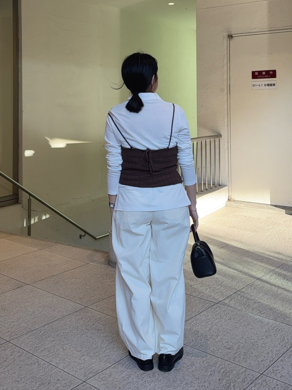 ブラウン系のキャミソール、ホワイト系のシャツ/ブラウス、ブラック系のローファーを着用したレディースの春コーディネートの2枚目の写真