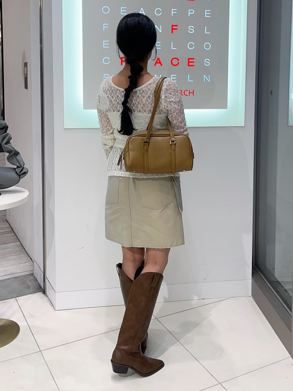 ホワイト系のTシャツ/カットソー、ベージュ系のスカート、ブラウン系のブーツを着用したレディースの秋コーディネートの3枚目の写真