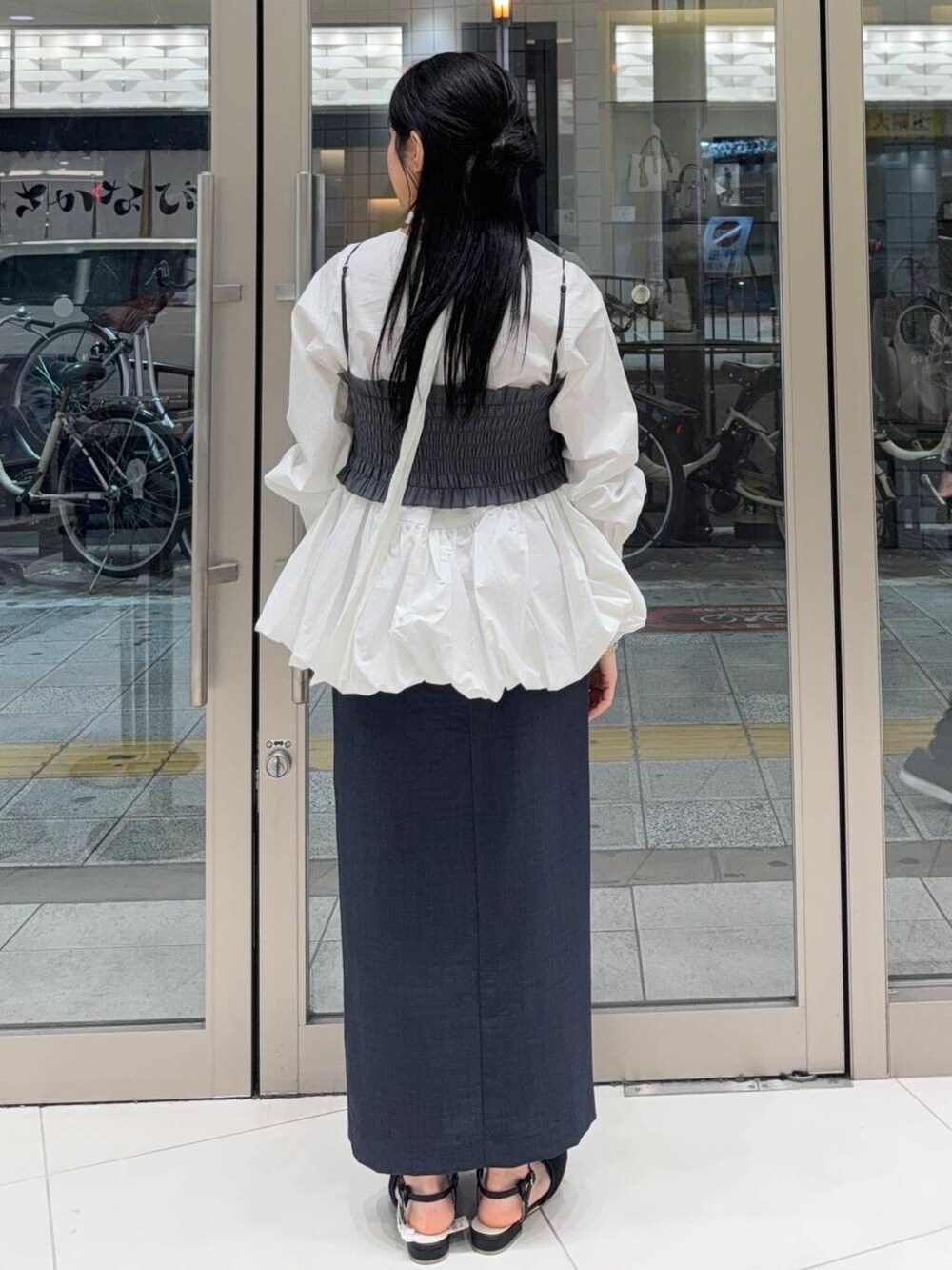 ブラック系のパンプス、ホワイト系のシャツ/ブラウス、グレー系のワンピースを着用したレディースの春コーディネートの2枚目の写真