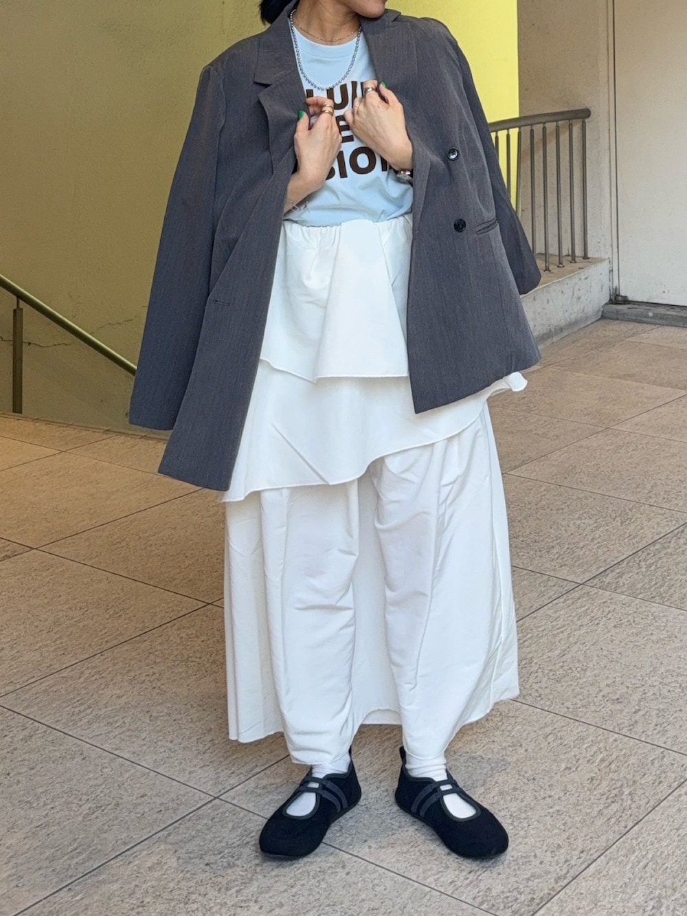 グレー系のテーラードジャケット、その他のTシャツ/カットソー、ホワイト系のスカートを着用したレディースの春コーディネートの2枚目の写真