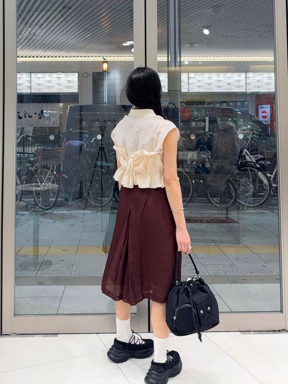 ブラック系のスニーカー、ホワイト系のキャミソール、ホワイト系のシャツ/ブラウスを着用したレディースの夏コーディネートの2枚目の写真